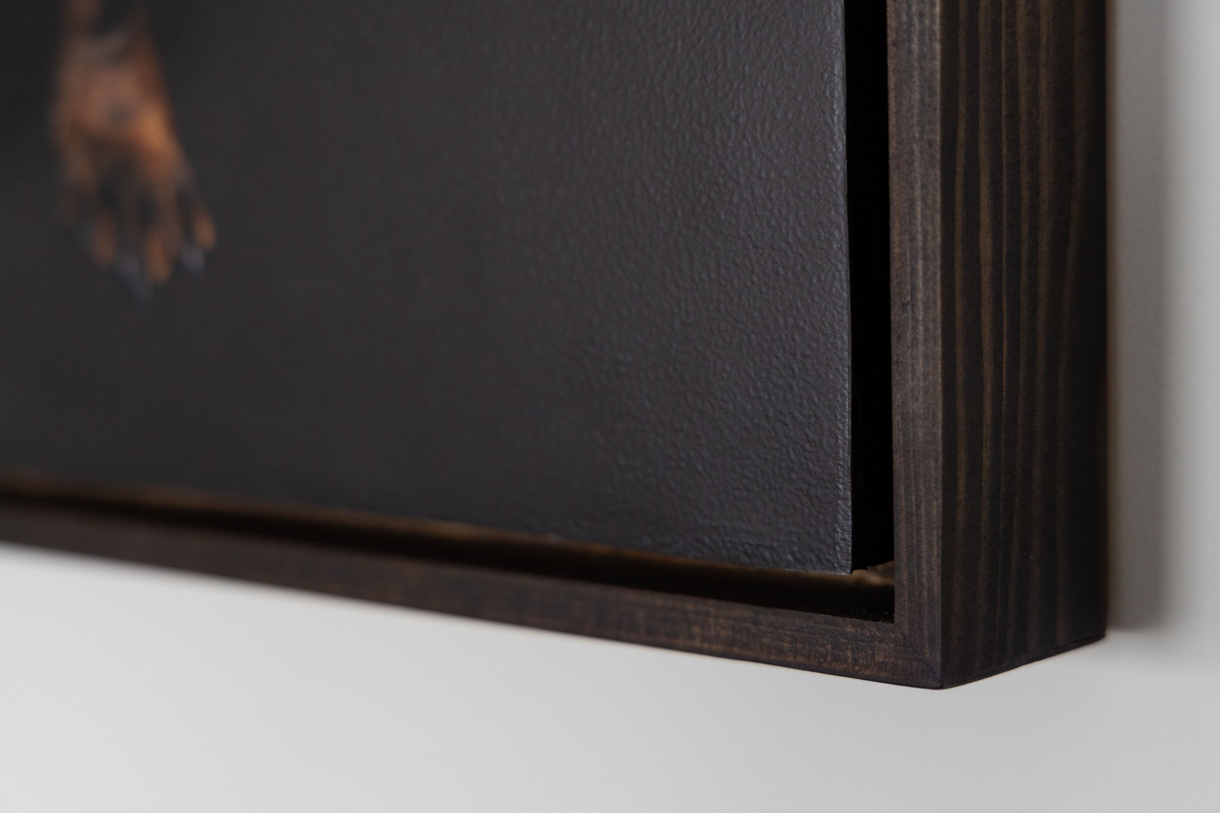 Close-up of a large, dark brown, textured wooden speaker with a small gap or opening visible between the panels.
