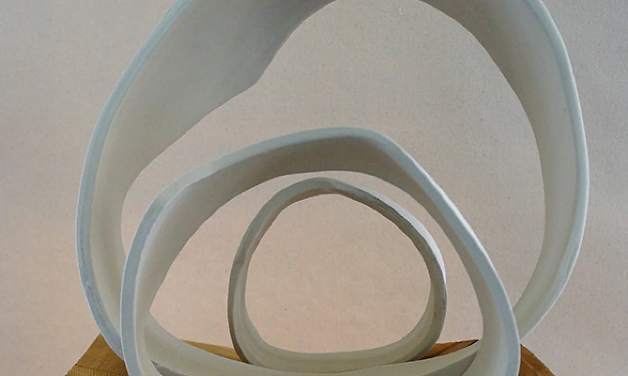 Multiple white circular objects arranged in a spiral pattern on a flat surface.