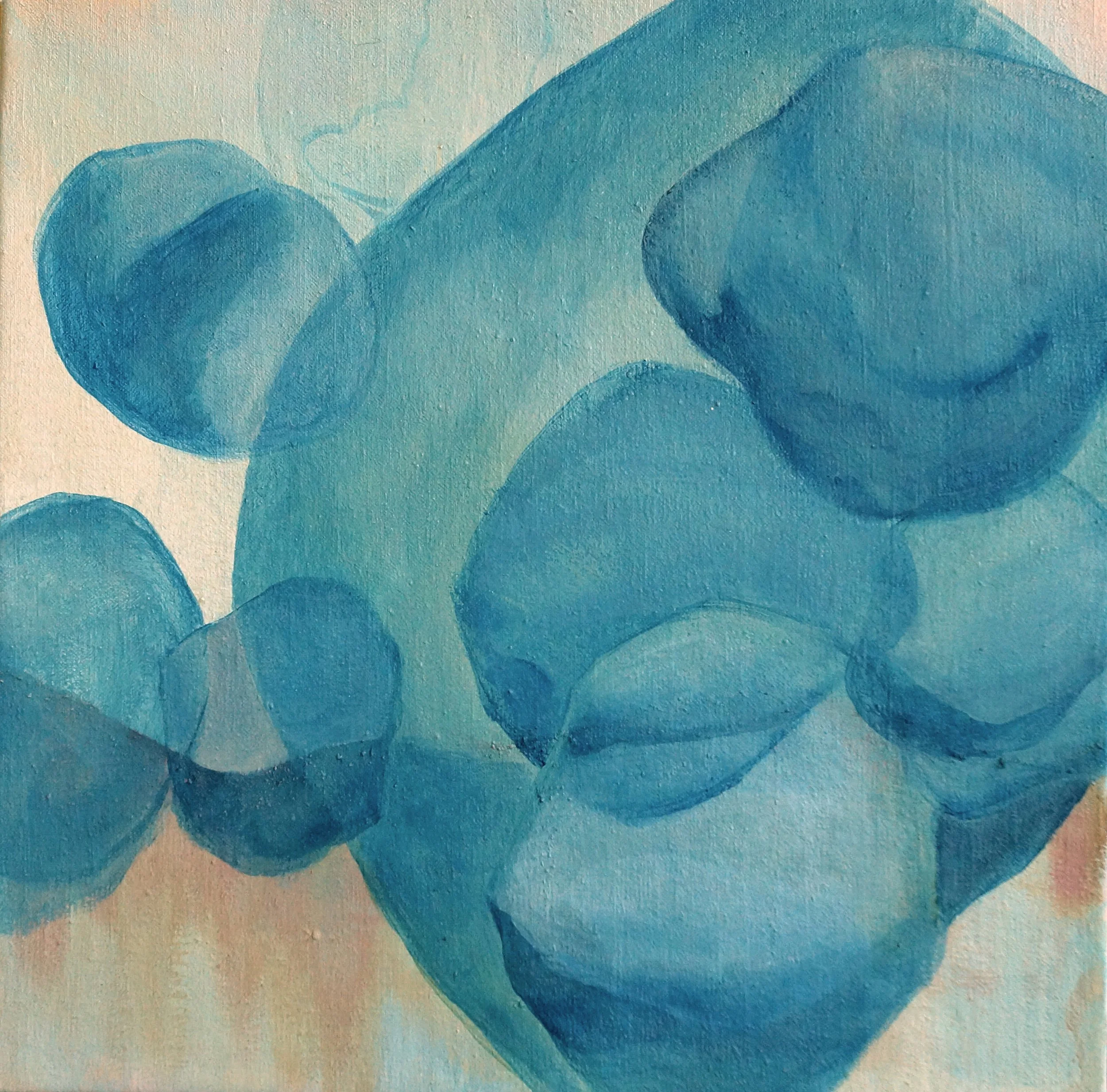 Close-up of an abstract watercolor painting with blue overlapping circular shapes on a textured paper background.