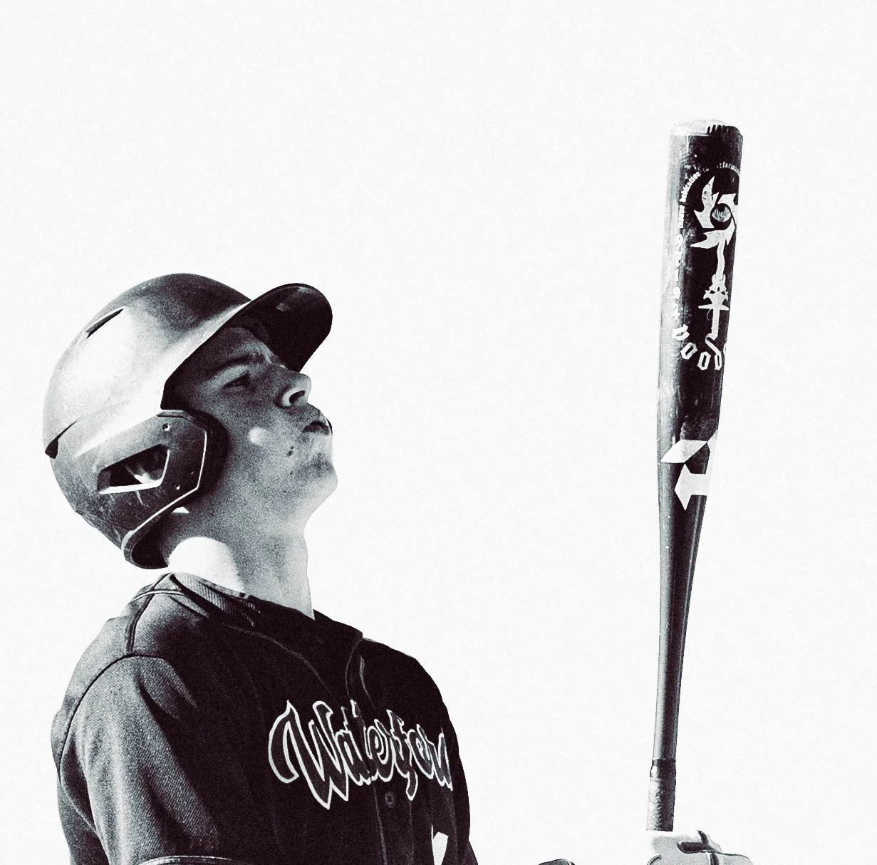 A young person wearing a helmet and a dark jacket, holding a baseball bat, looking upward, in a high-contrast black and white photo.