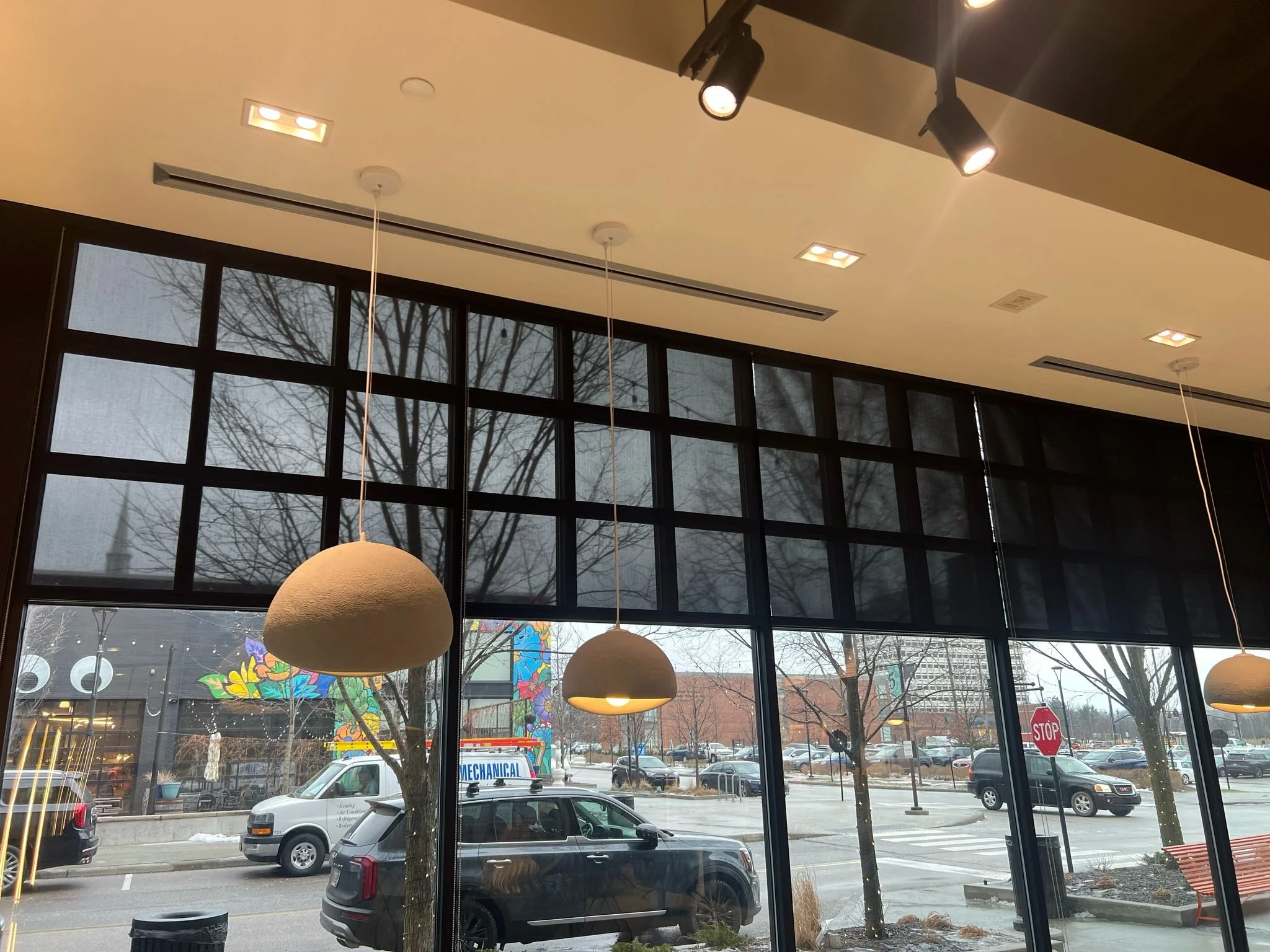 Interior of a restaurant or cafe with large windows motorized shades installed in Cleveland Ohio by Rose Custom Window Treatments