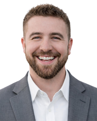 A smiling man with short hair and a beard, wearing a gray suit jacket and white shirt. Jon Gilliam
