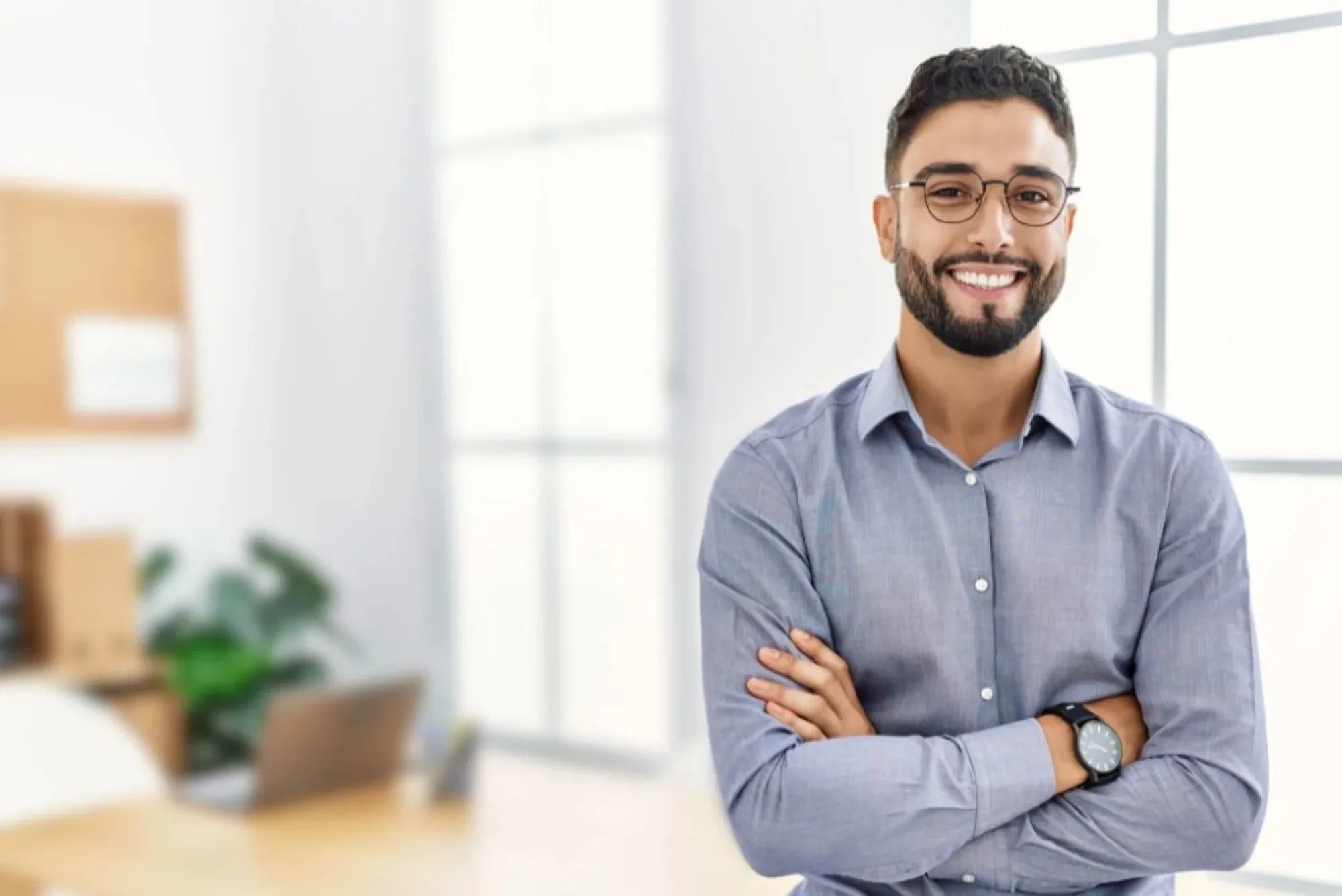 A smiling, young, professional man in an office setting