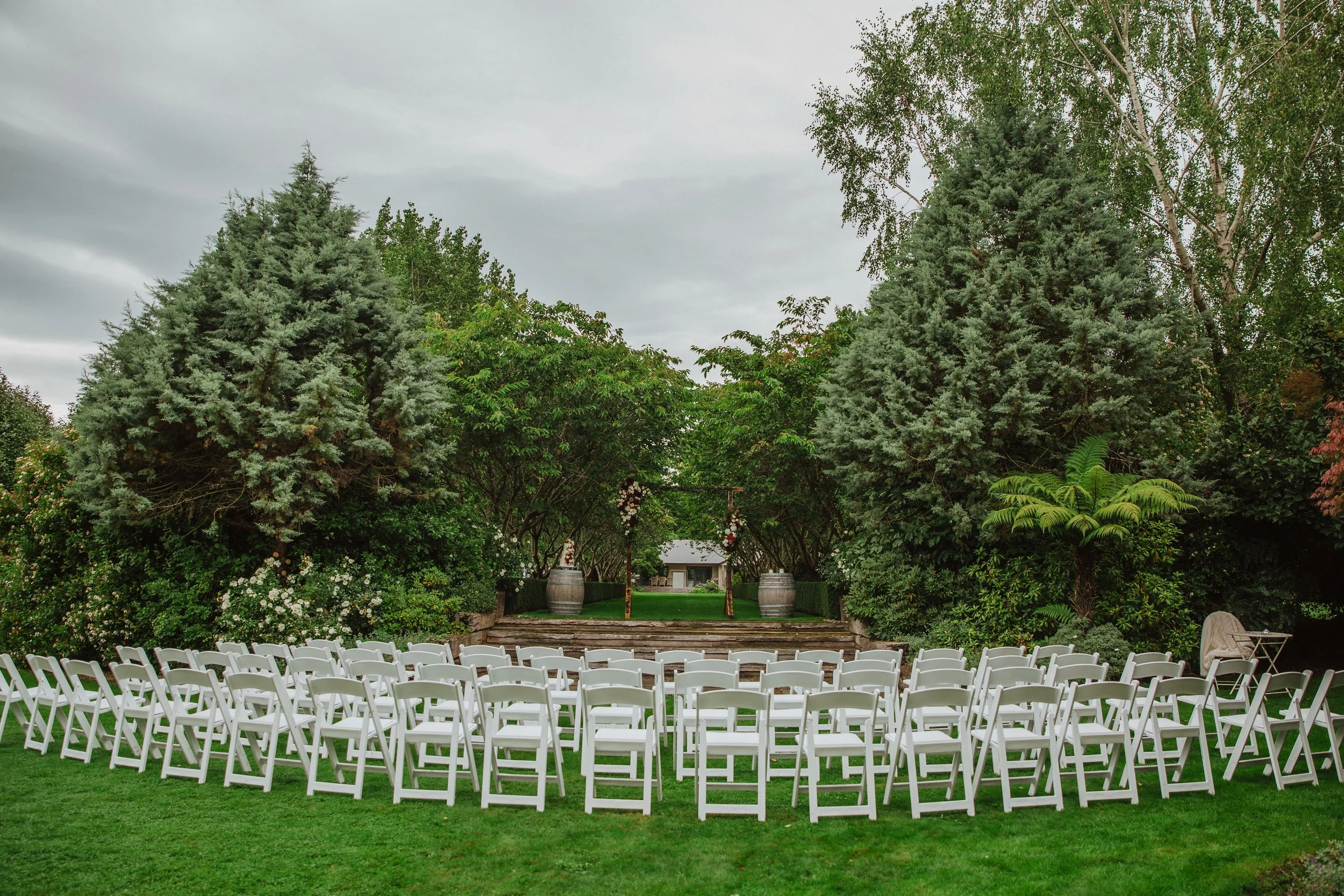 Wedding ceremony chairs and archway with florals