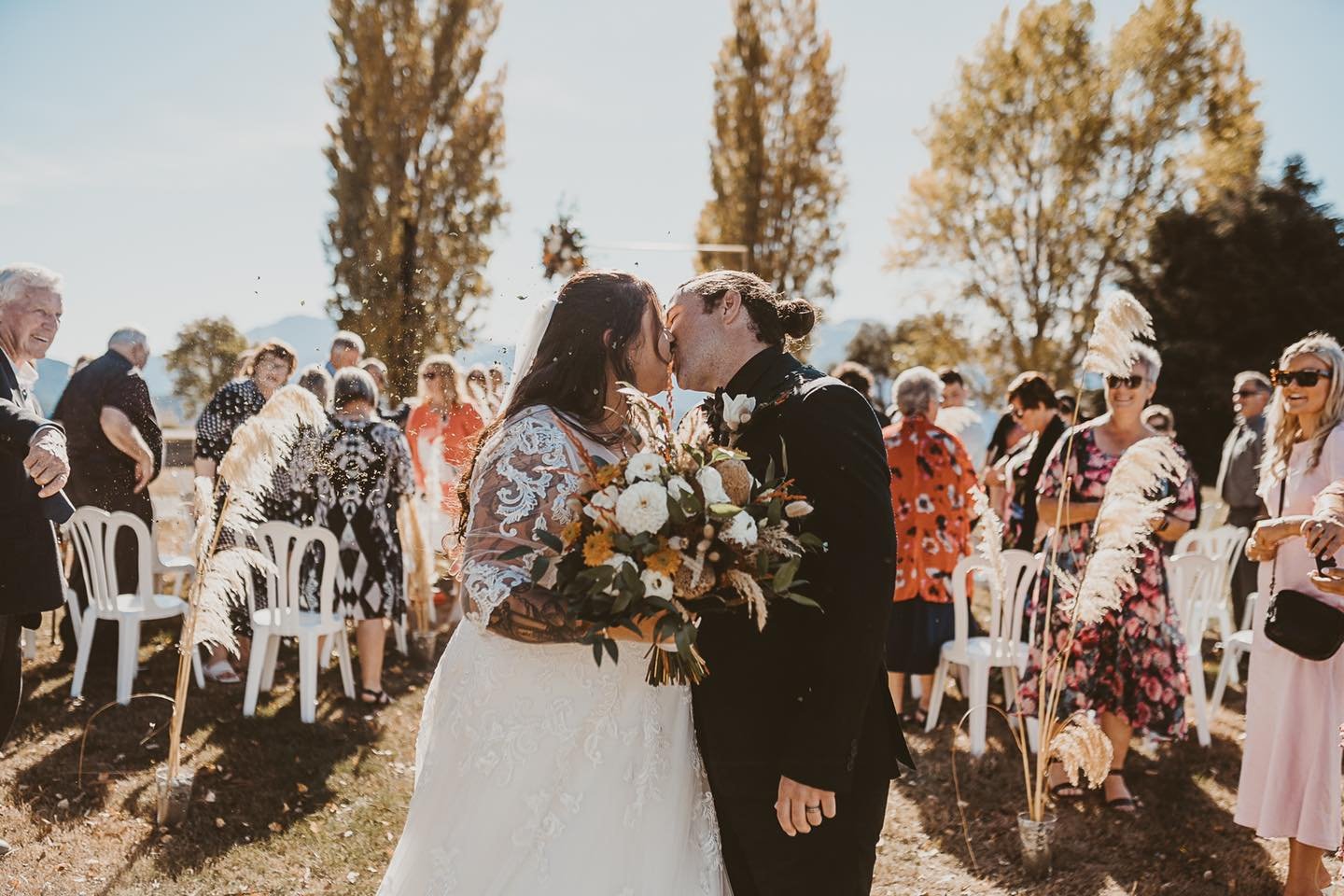Wedding ceremony first kiss lakefront bride and groom