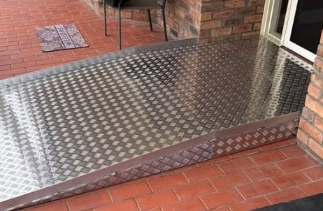 Metal diamond plate platform on a brick patio.