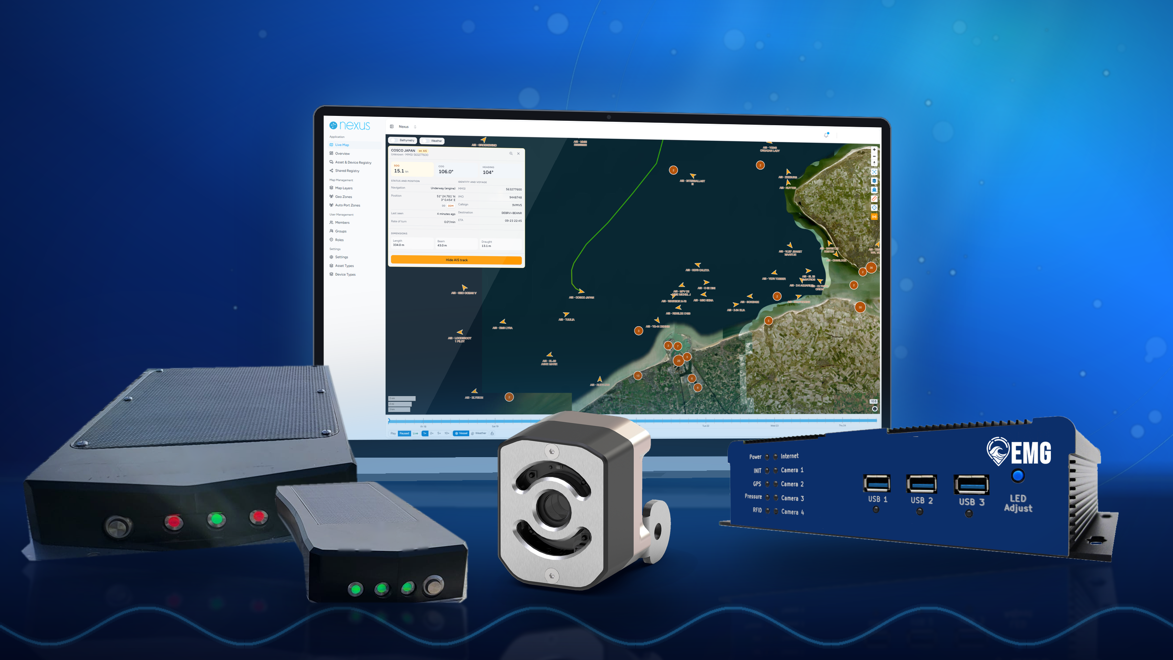 A computer monitor displaying a maritime navigation map with boat icons, radar data, and geographic information. Surrounding equipment includes a black box, a camera, and various control modules.
