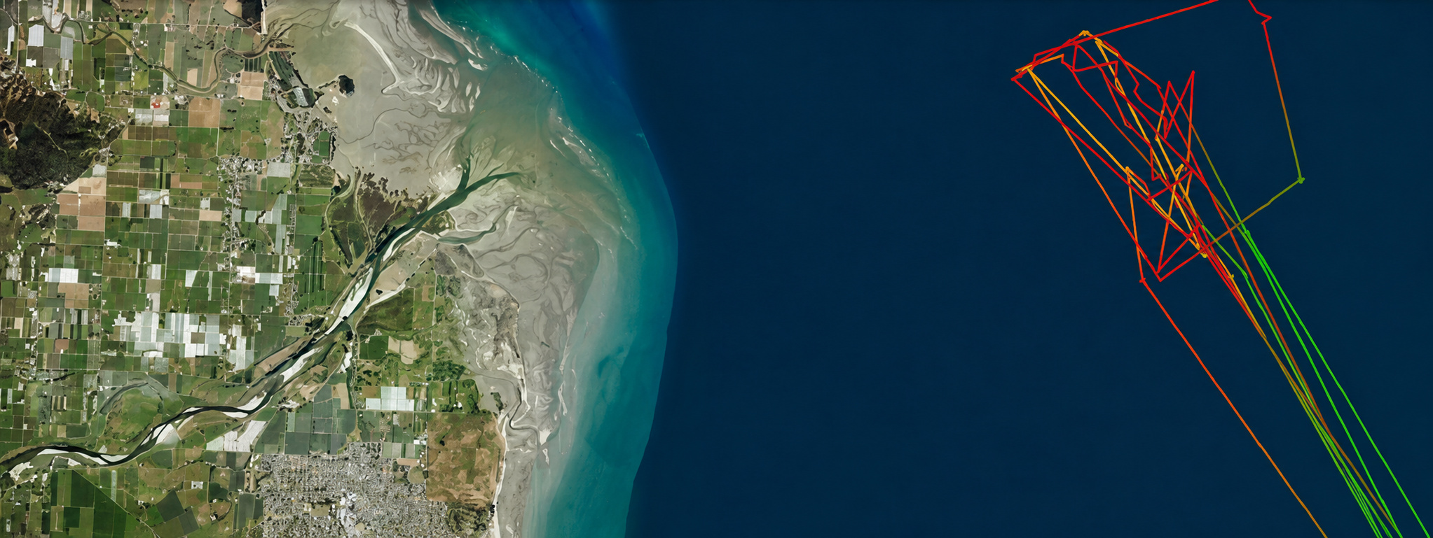 Satellite image of a coastal area with agricultural fields, a river delta, and a shoreline, overlaid with colored lines indicating offshore paths or data routes.