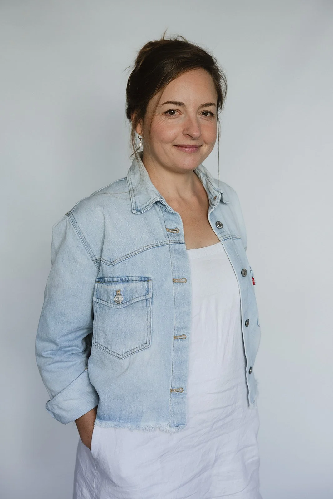 Lucinda Opper, murder mystery author, cozy crime, comic novels, portrait, blue denim jacket and white dress.