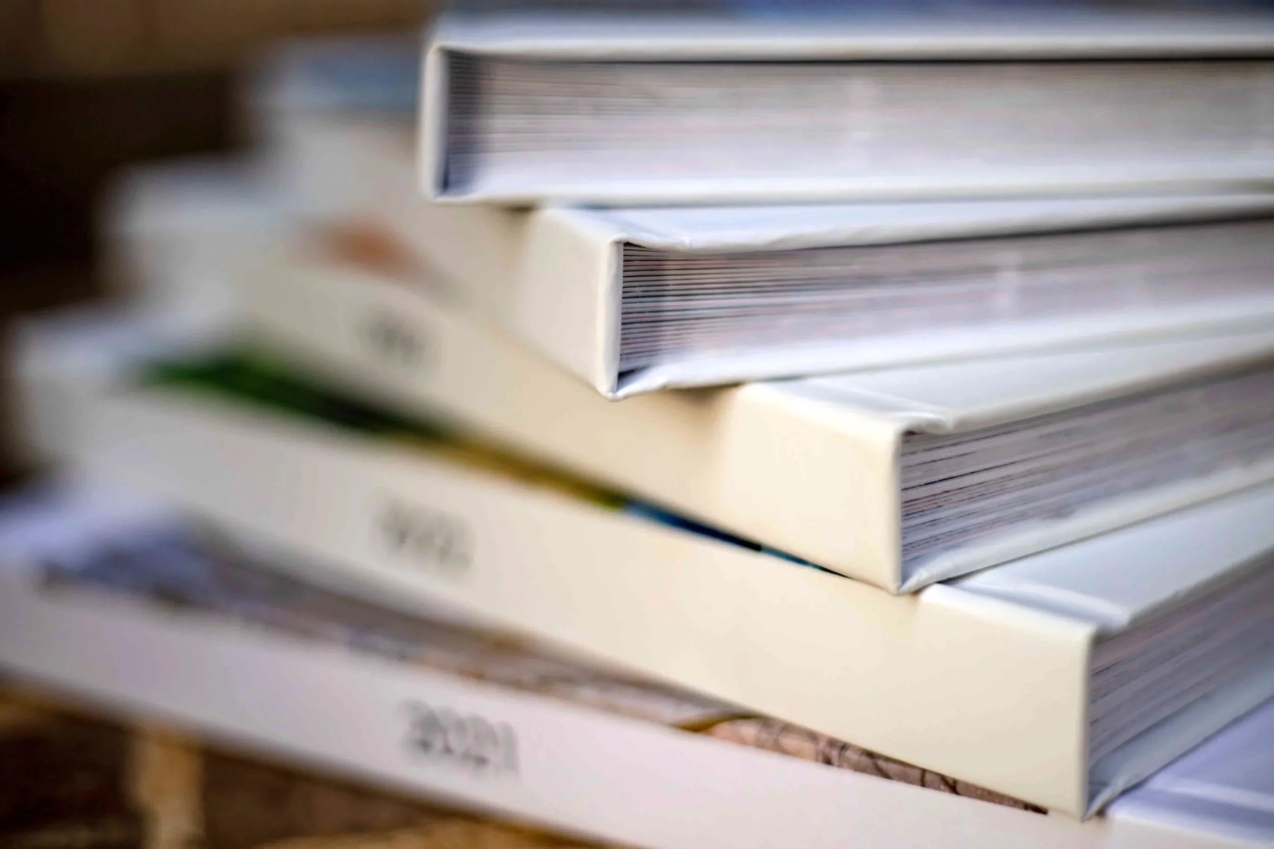 Stacked paper or cardboard sheets with visible lines and edges, slightly blurred.