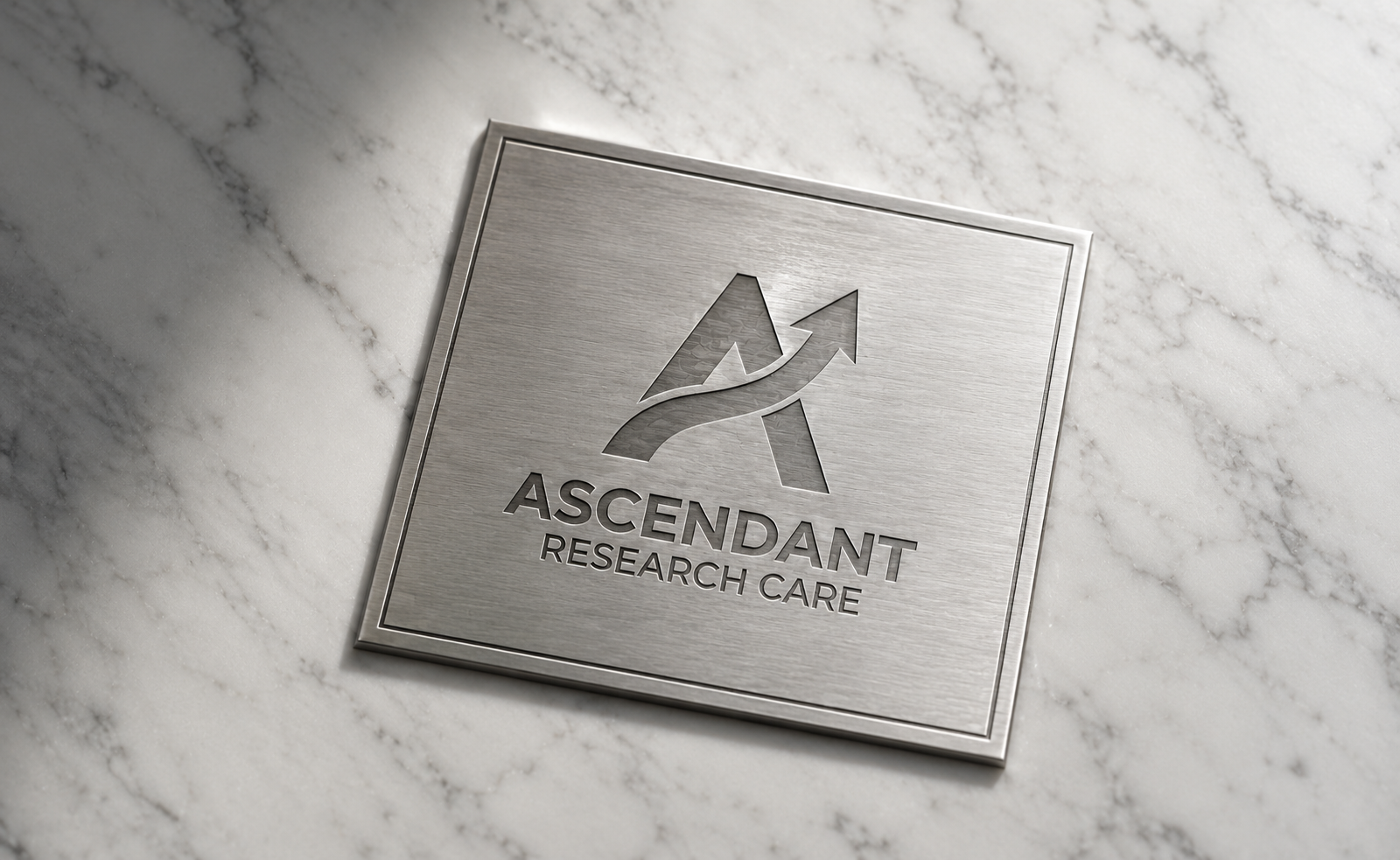 Metal plaque with logo and text for Ascendant Research Care on a marble surface.