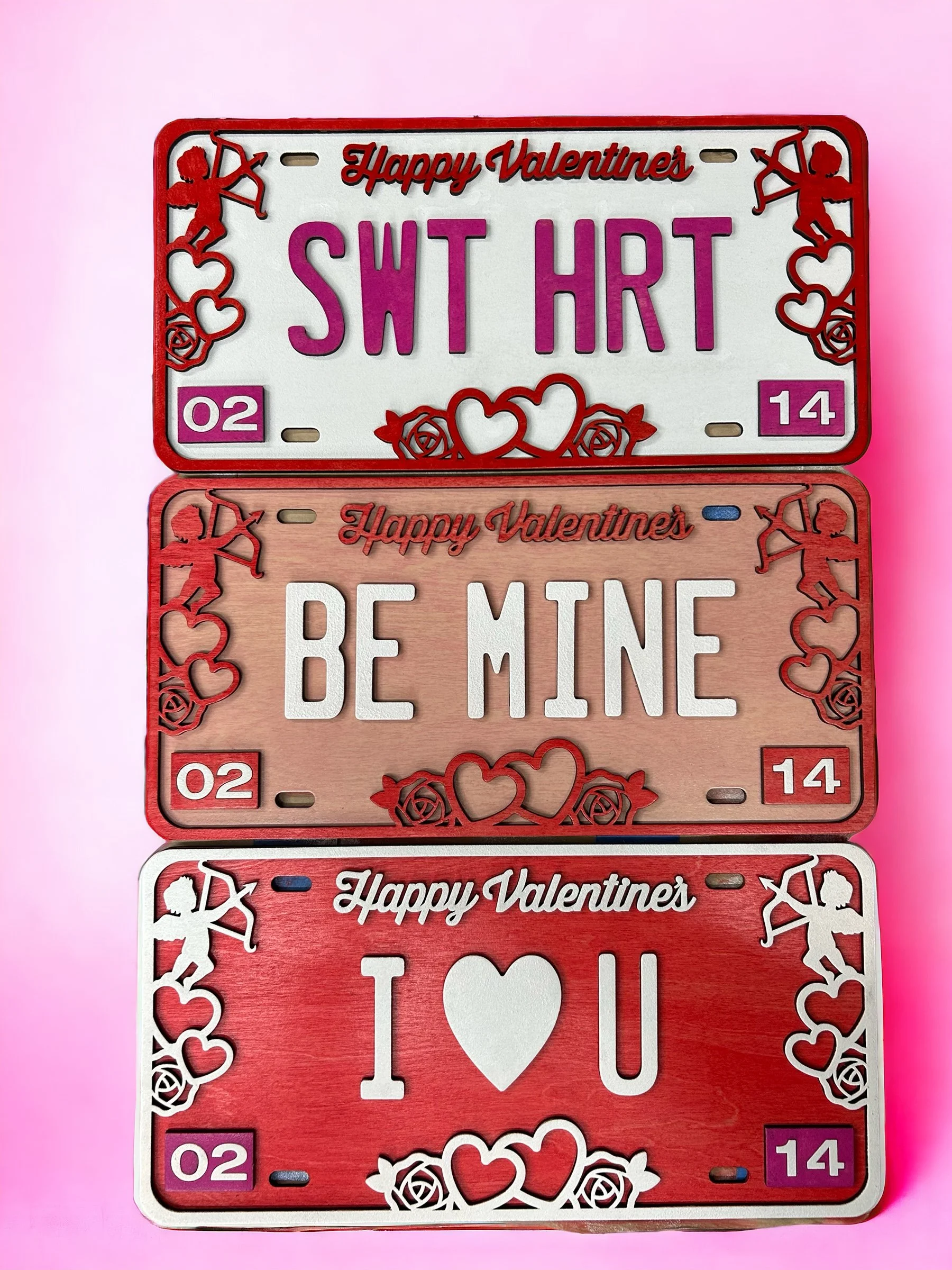 Valentine's Day inspired wooden license plates in Red, pink, and white motifs.