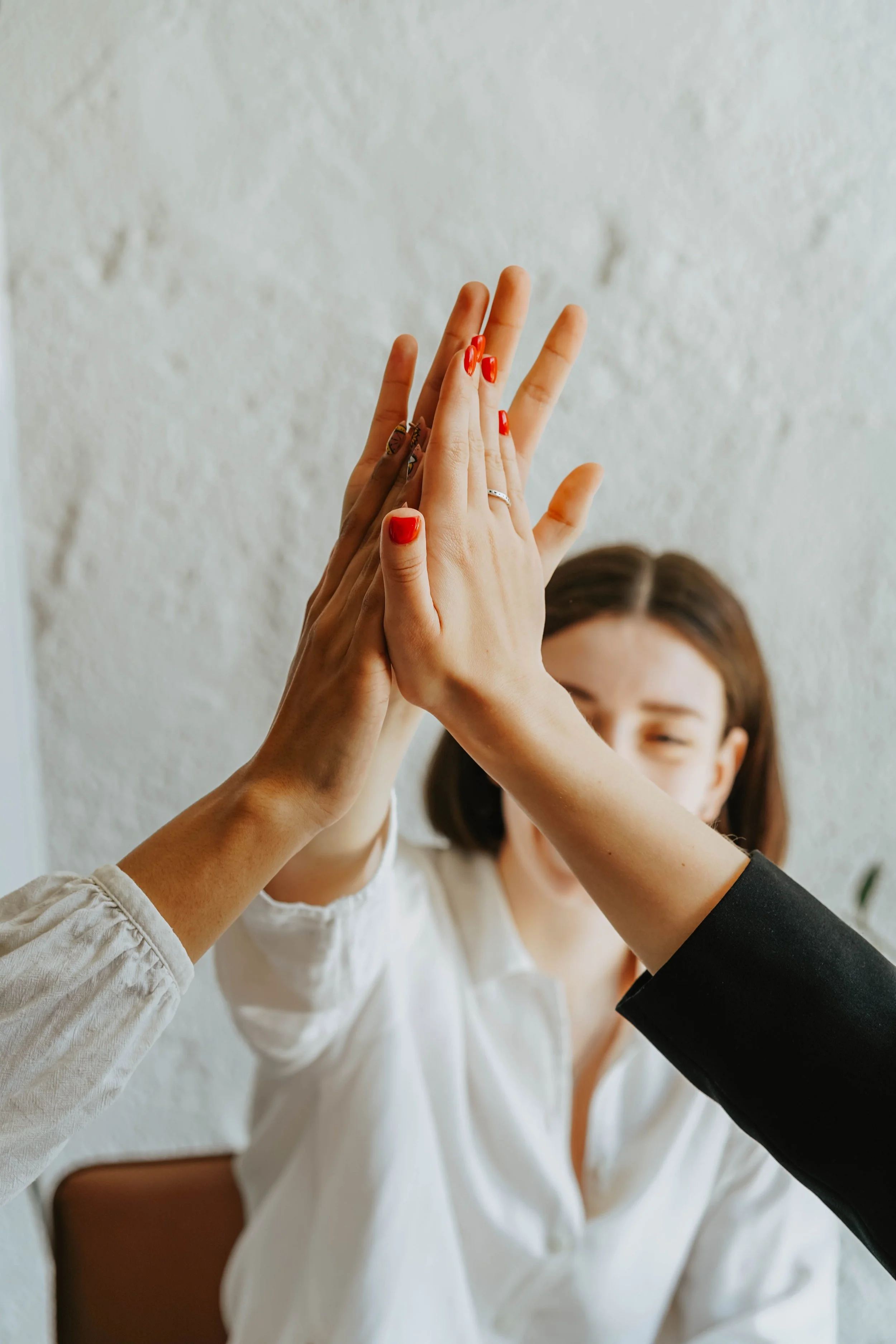 People of different backgrounds sharing a high-five — welcoming, inclusive nutrition care