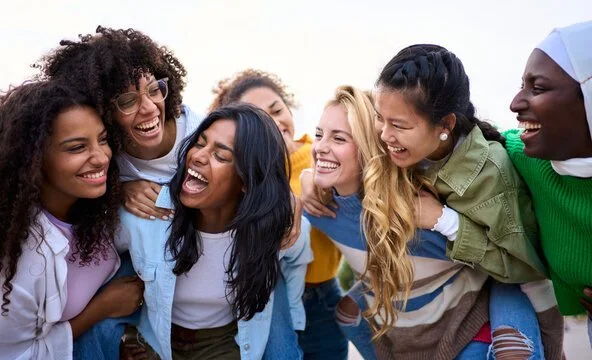 Group of diverse young women laughing and smiling together outdoors