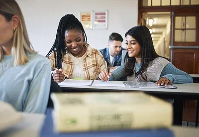 Group of diverse students studying together at a table in a classroom.