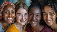 Four smiling young women standing close together.