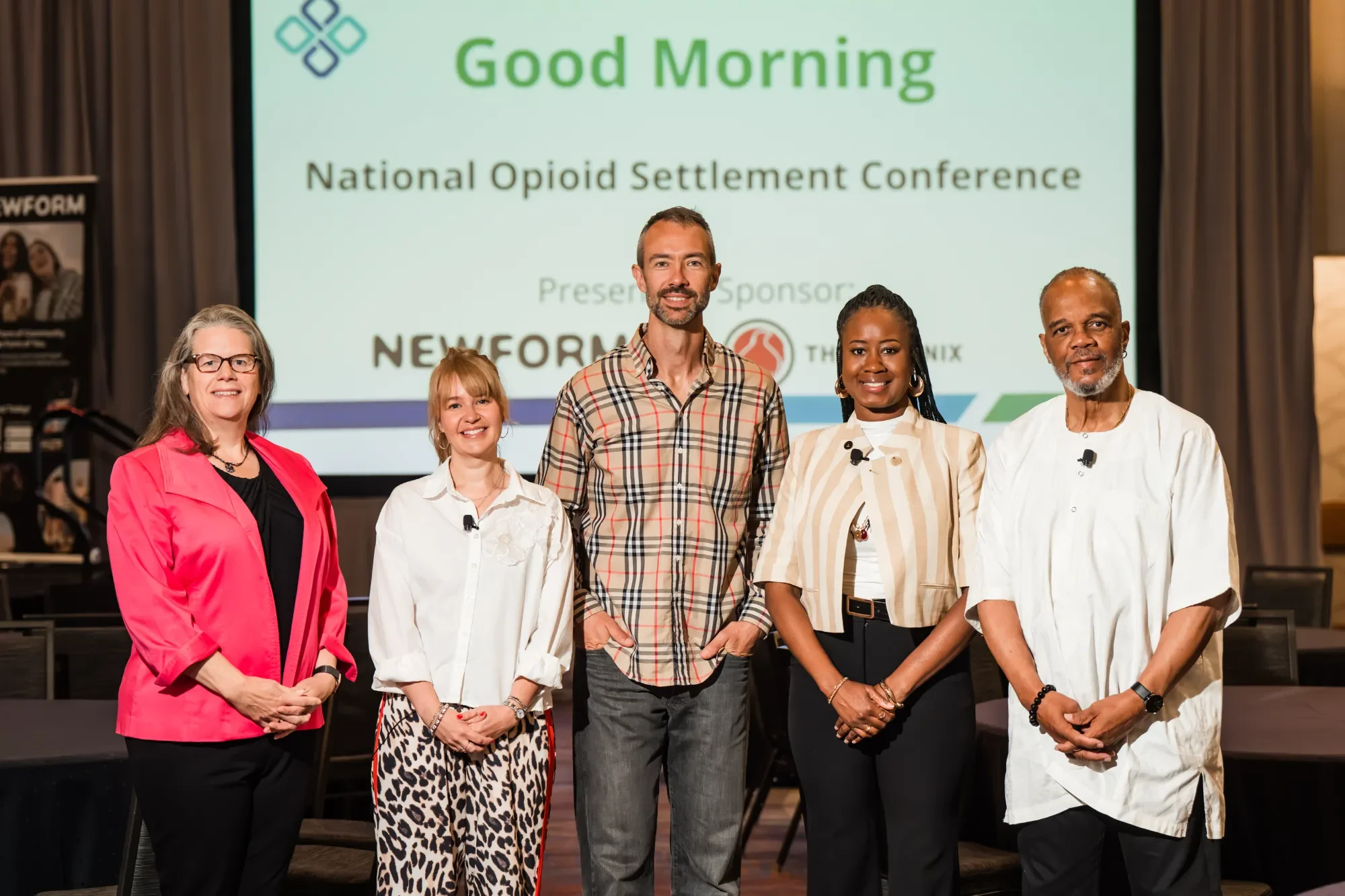 NOSC team standing in front of a presentation screen with a logo and the text 'Good Morning National Opioid Settlement Conference' at a conference or event.