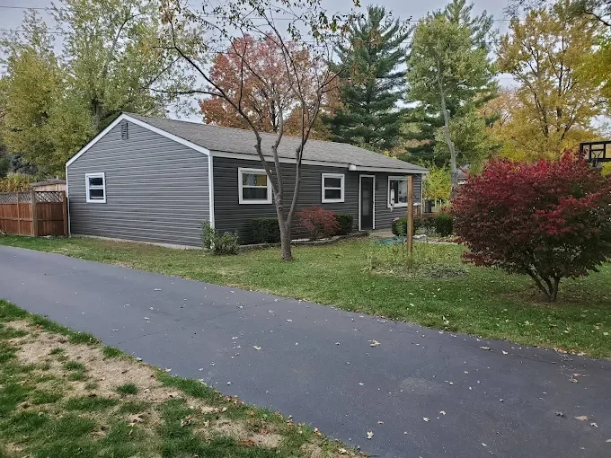 Siding installation with budget friendly siding, new trim, window and door metal wrapping. Contrast of dark grey siding and bright white trim create beautiful curb appeal. Example for Lansing, Grand rapids, Ann Arbor area project