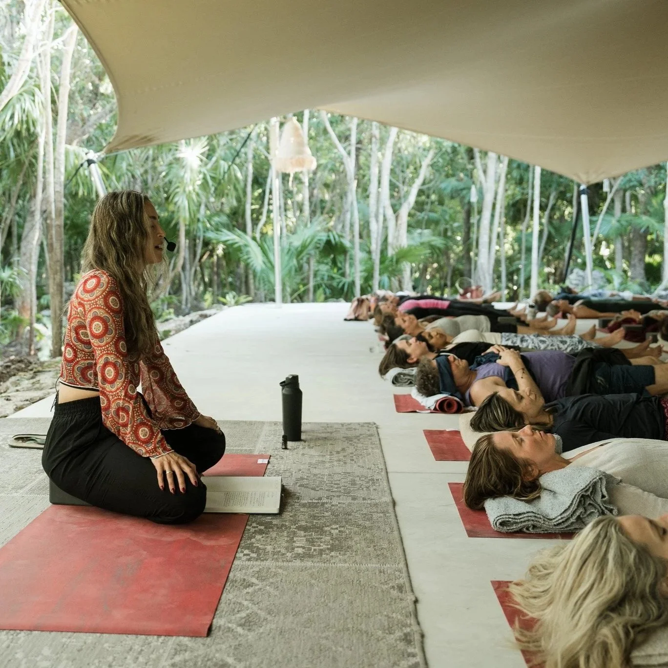 Mindfulness teacher Rosie Acosta guiding a group meditation and savasana practice during a wellness retreat at Palmaïa The House of AïA in Riviera Maya, Mexico.