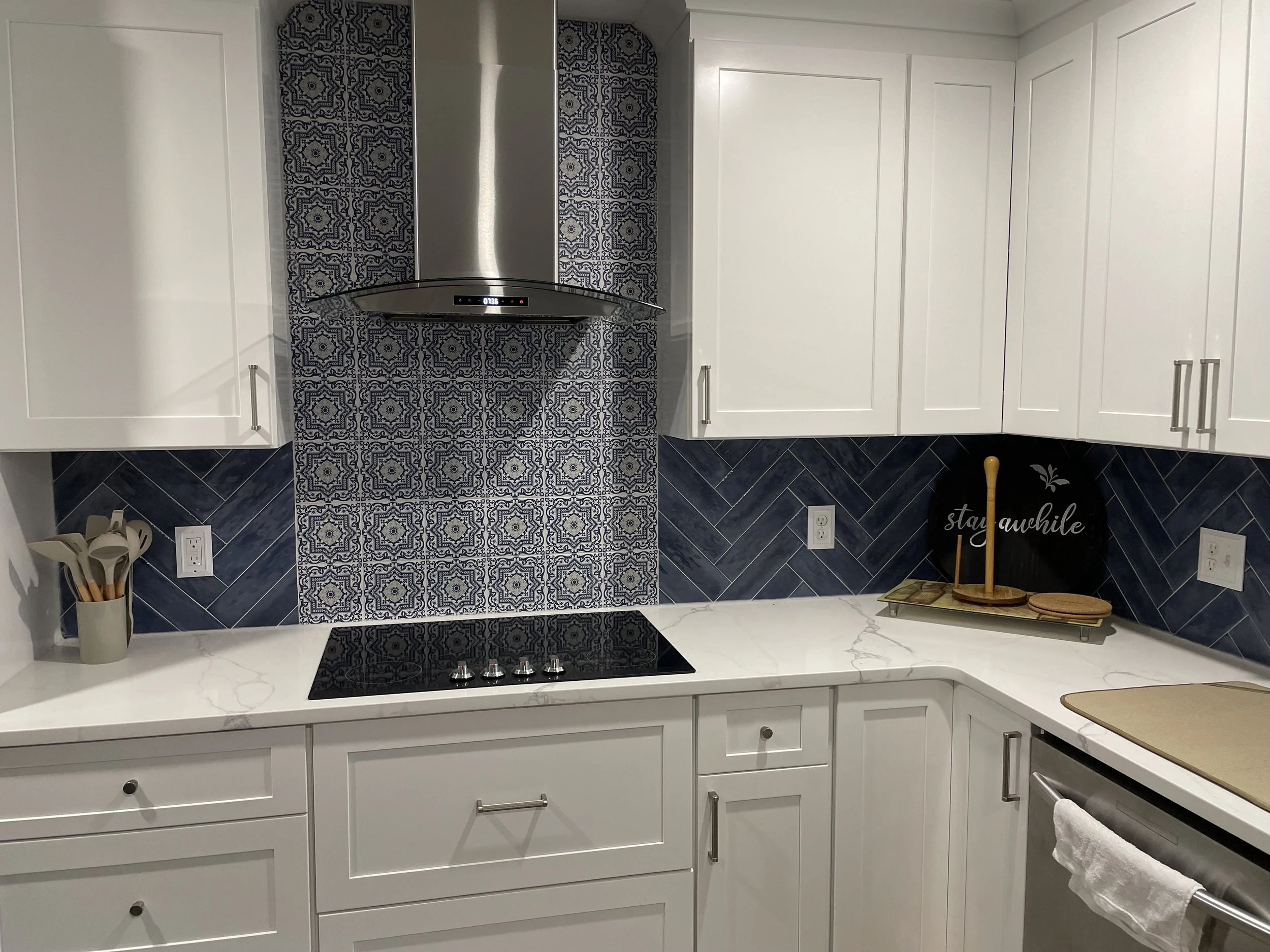 Herringbone backsplash and accent wall behind stove and hood.
