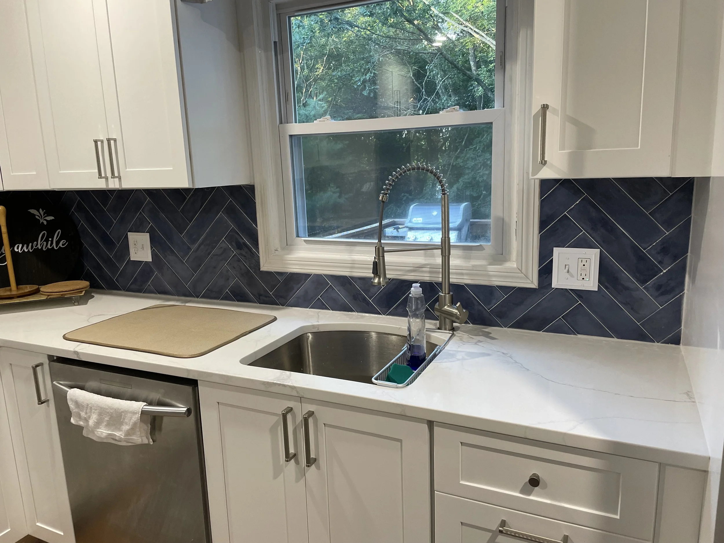 Herringbone tile installed around kitchen window.