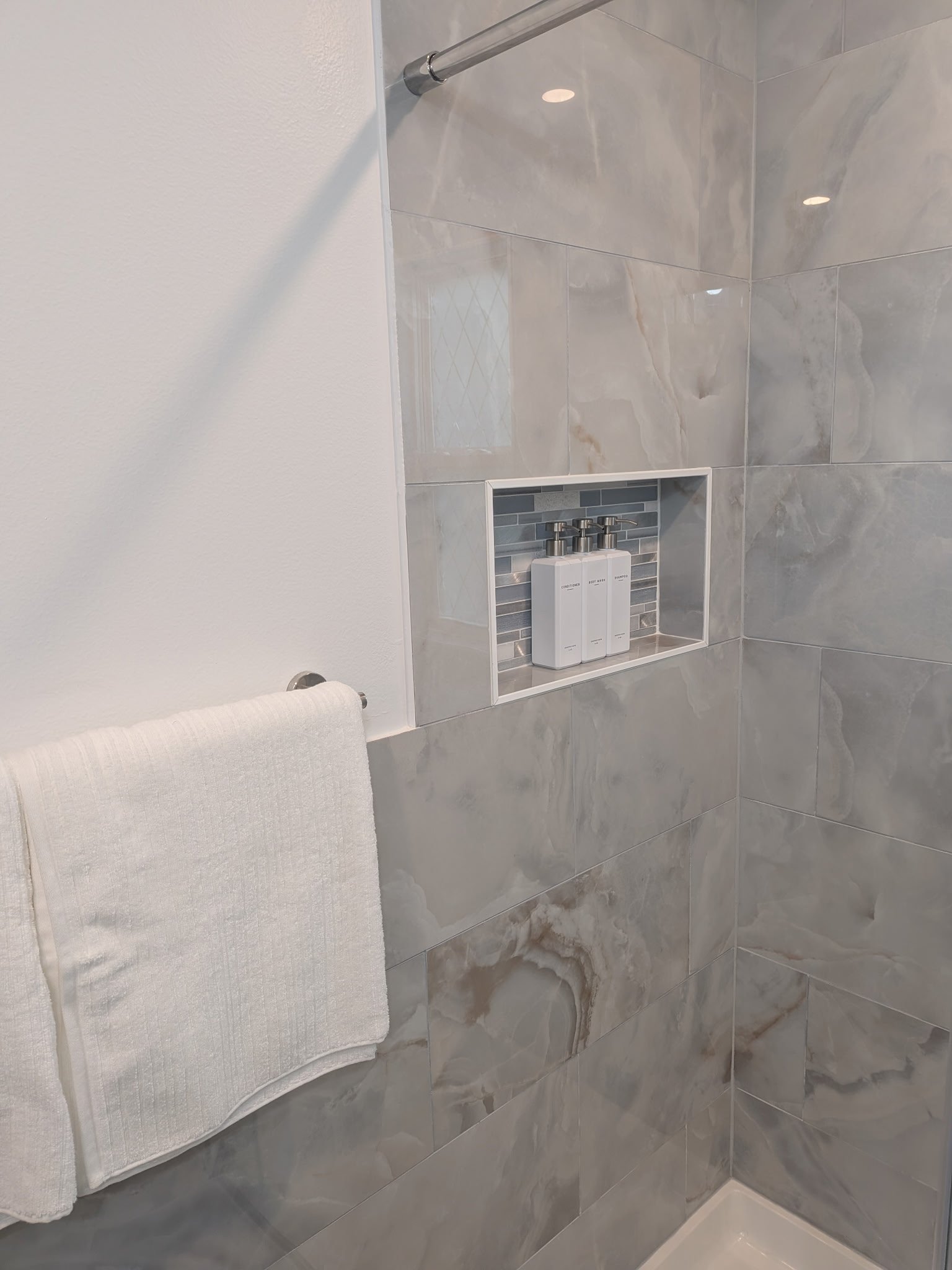 Custom shower niche with Schluter trim and accent field tile.