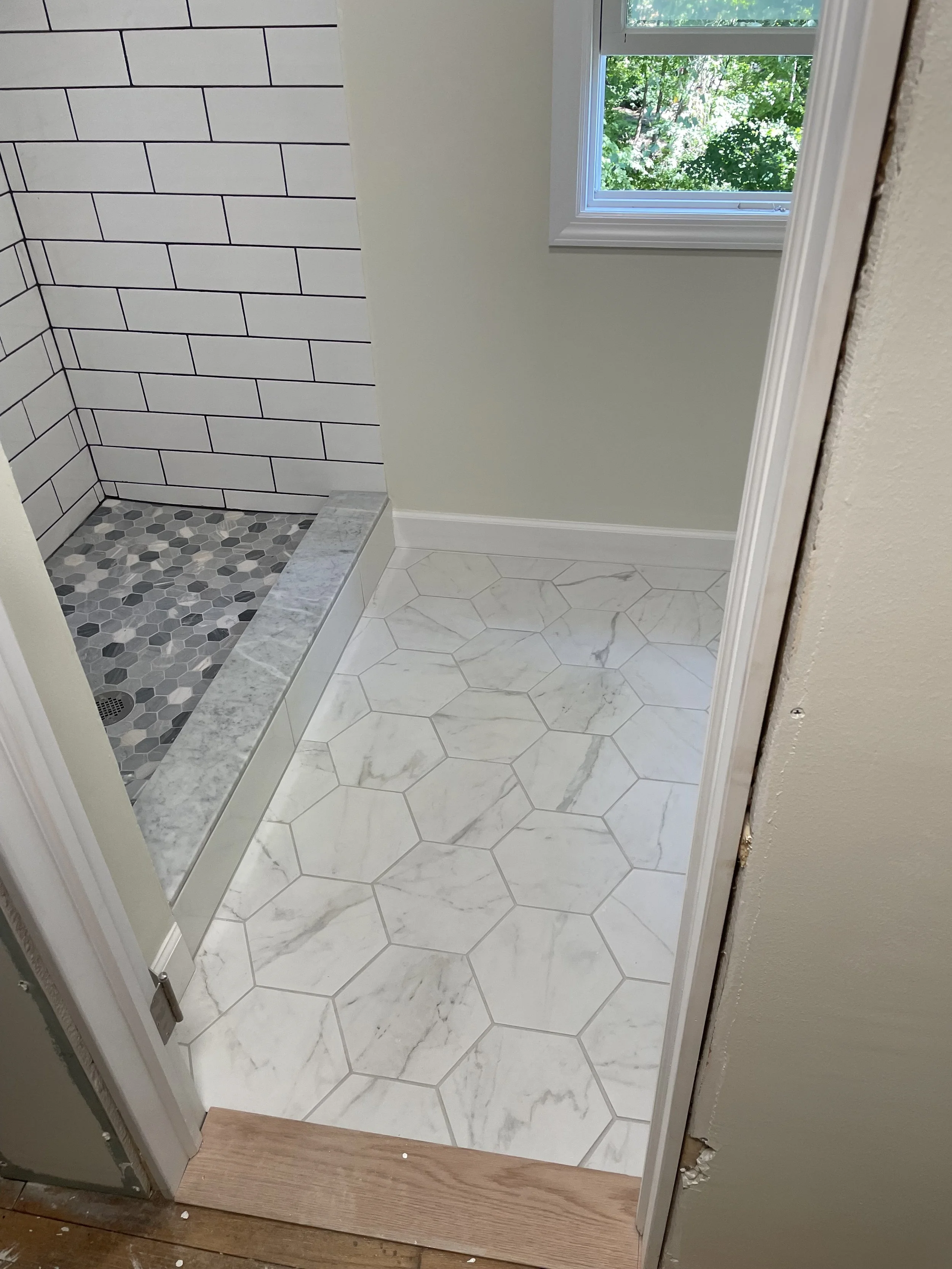 Full bathroom remodel with hexagonal floor tile, shower walls with subway tile, and a mosaic shower floor.
