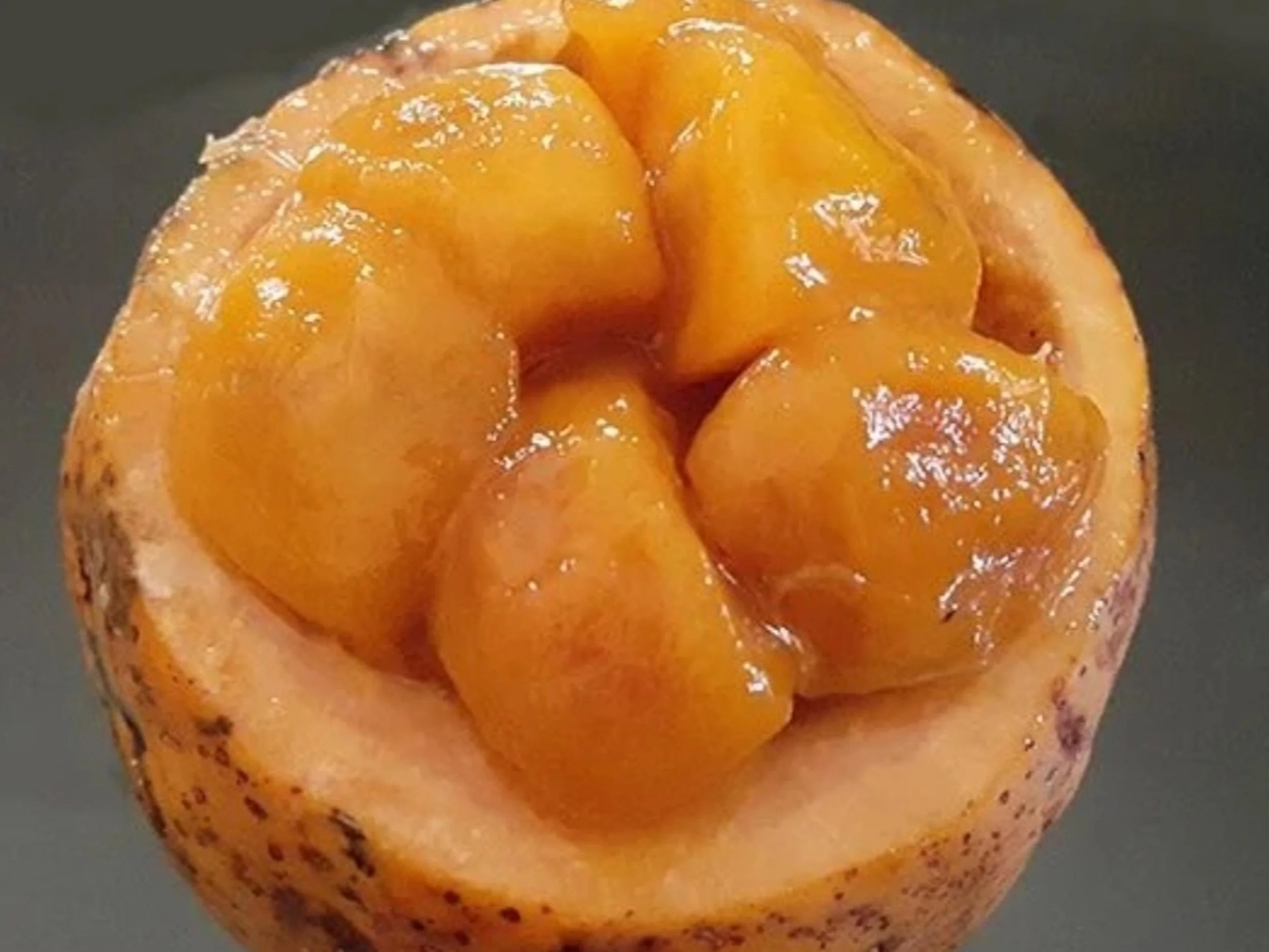 Close-up of a roasted, peeled yellow habanero pepper with charred spots.