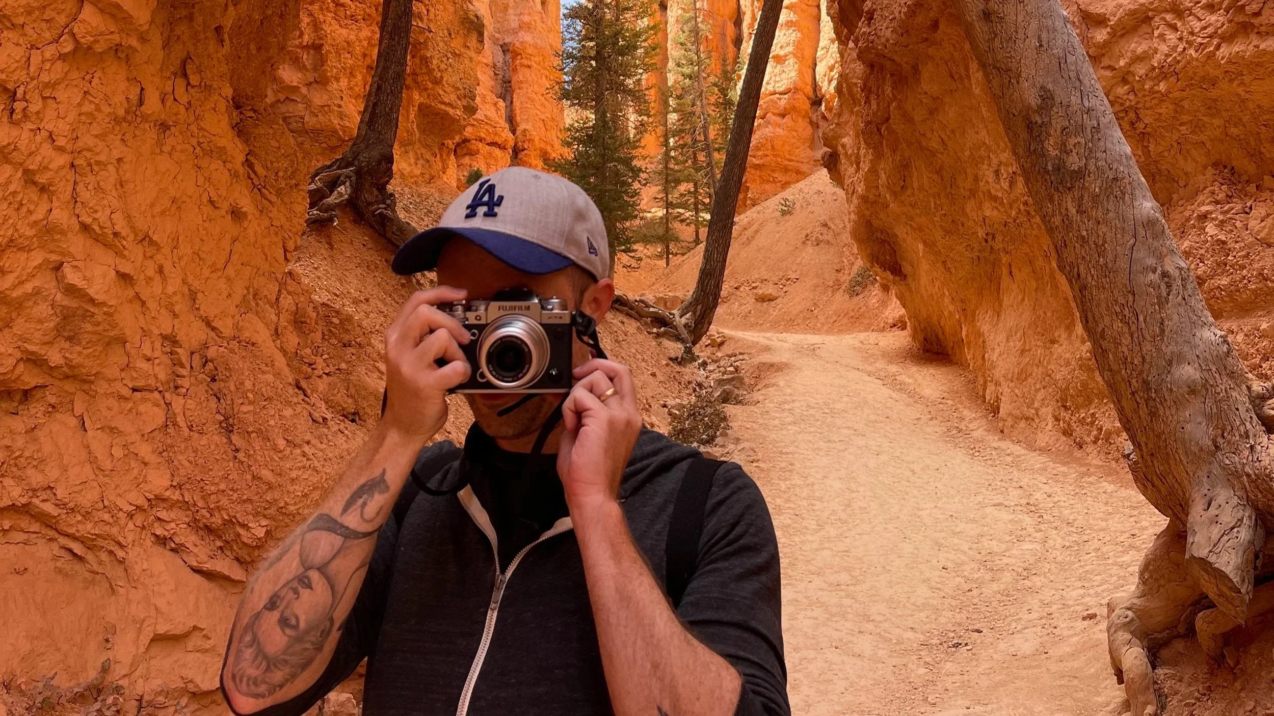 Brandon Sieve holding a camera while hiking through Bryce Canyon National Park in Utah.