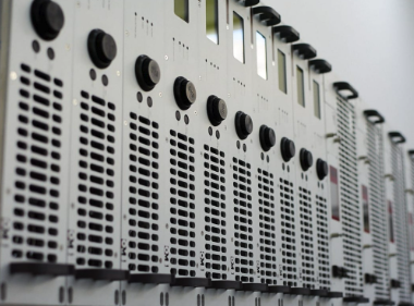 Close-up of a data server rack with multiple vents and control panels.