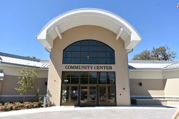 Front view of a community center building with large glass windows and a sign that reads 'Community Center'