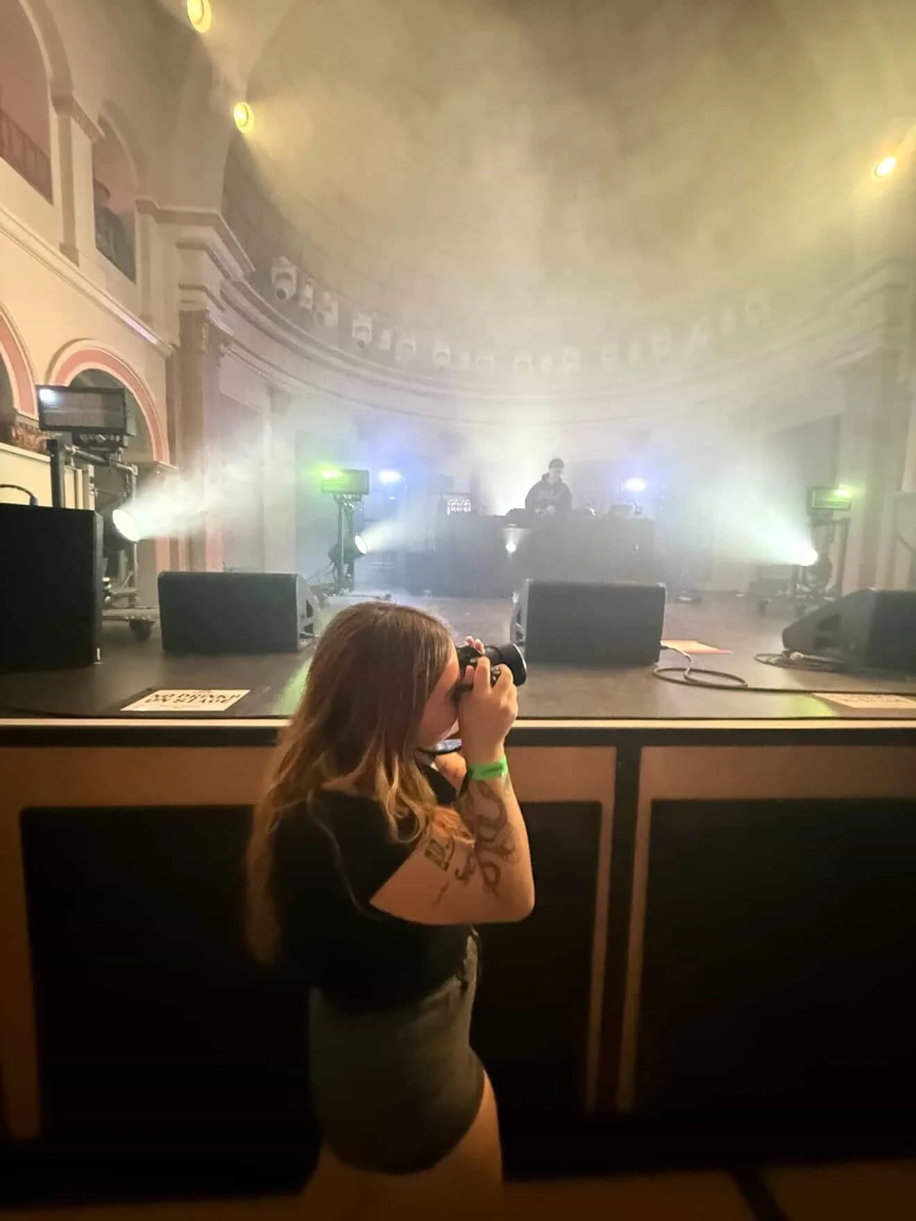 Sedona Naumcheff taking a photo of stage with a DJ at La Rosa Venue.