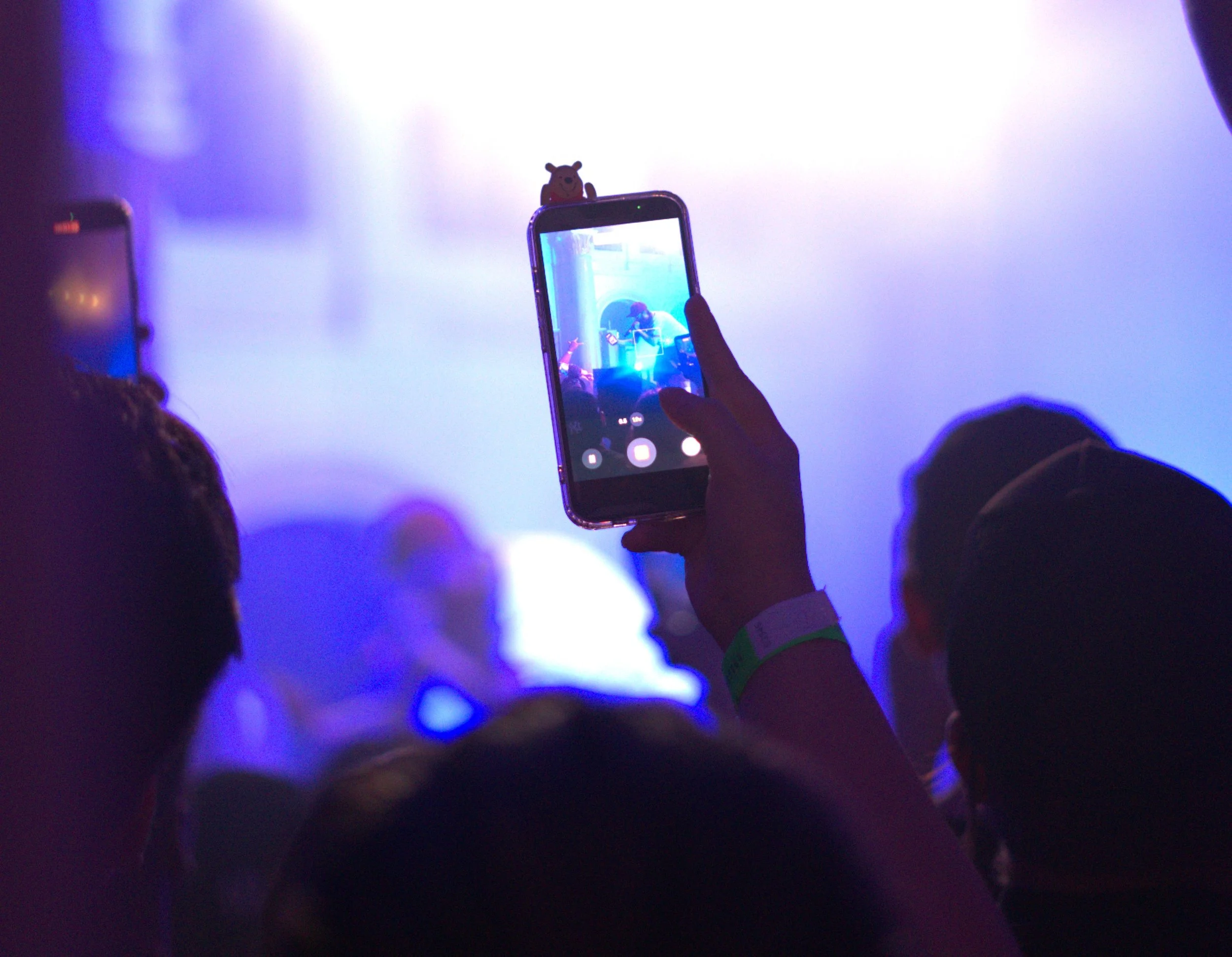 A photo of a phone taking a photo of Freddie Dredd on stage.