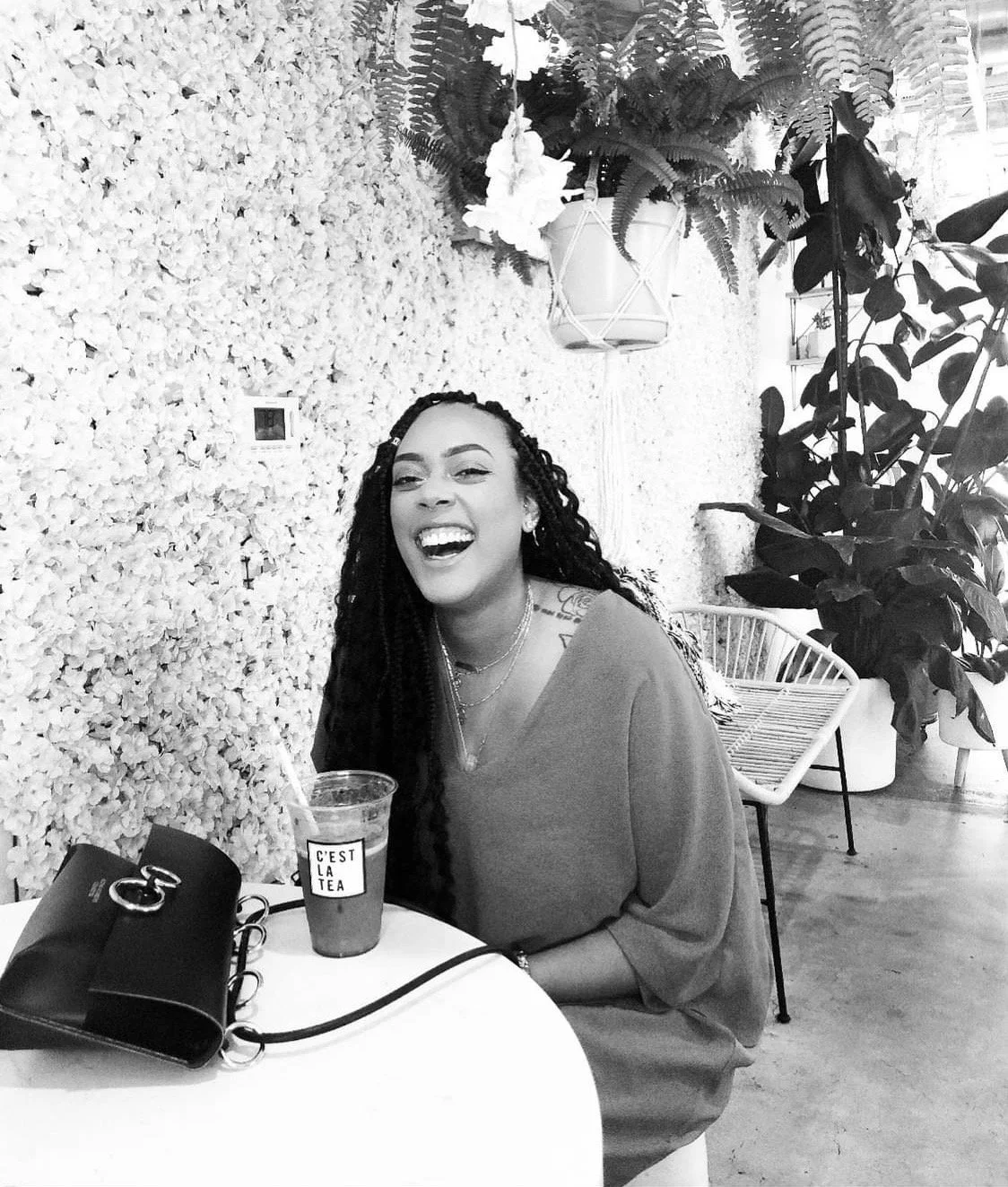 Janelle Chanté, founder of Noir Jardin, laughing warmly in a black and white photo.