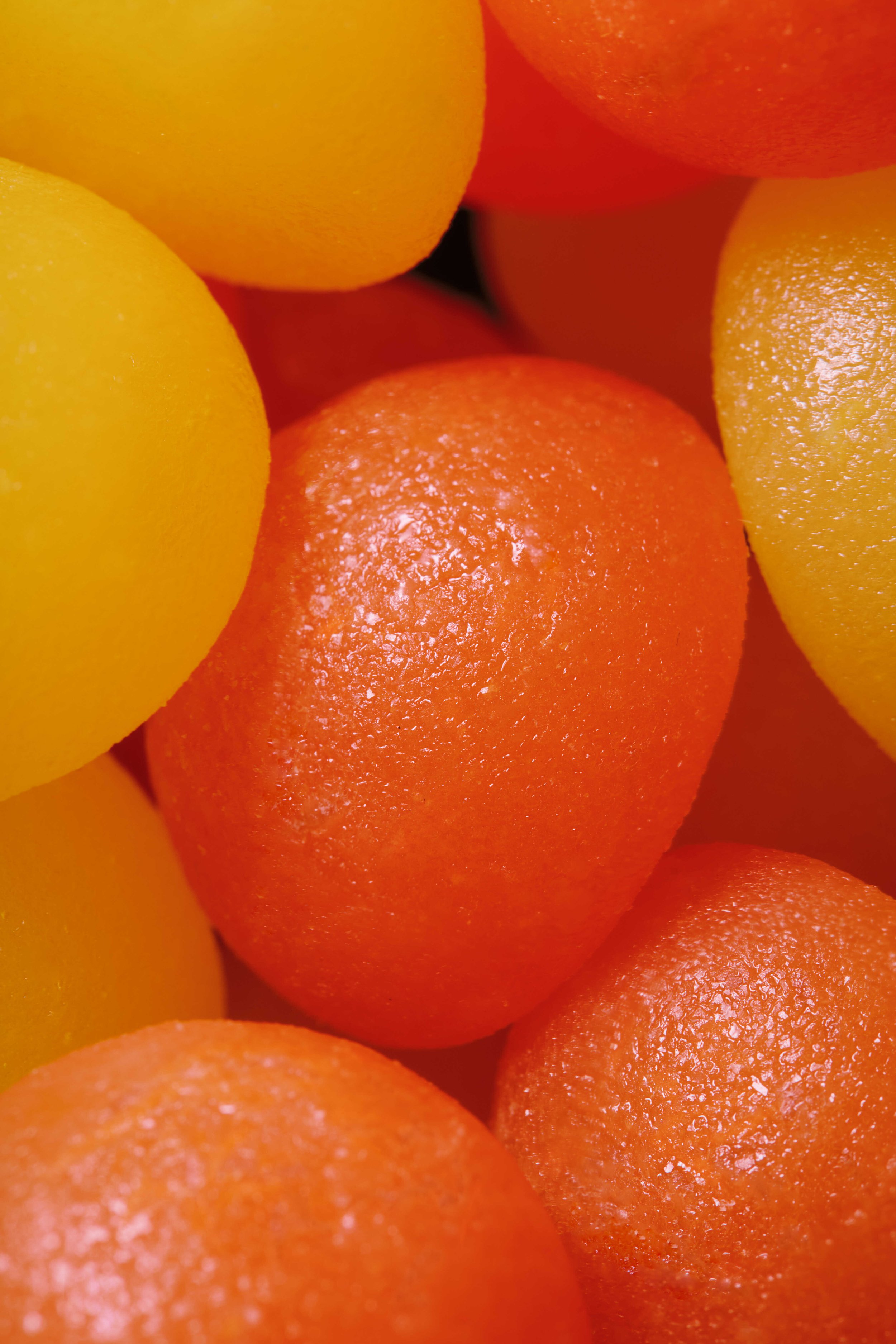 Close-up image of several orange and yellow spheres with textured surfaces.