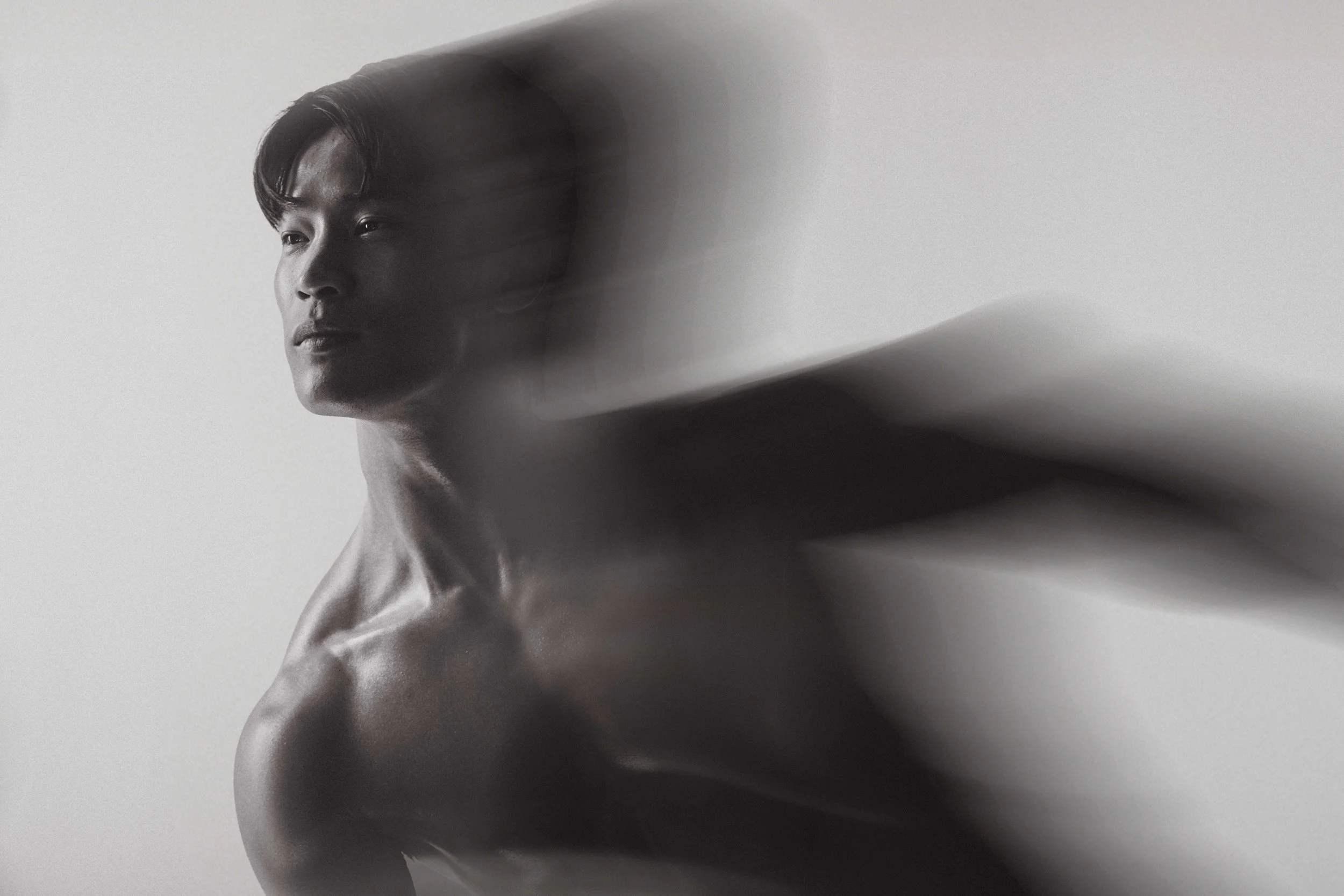 Black-and-white photo of a woman with short hair looking to the side, with soft lighting and a blurred background.