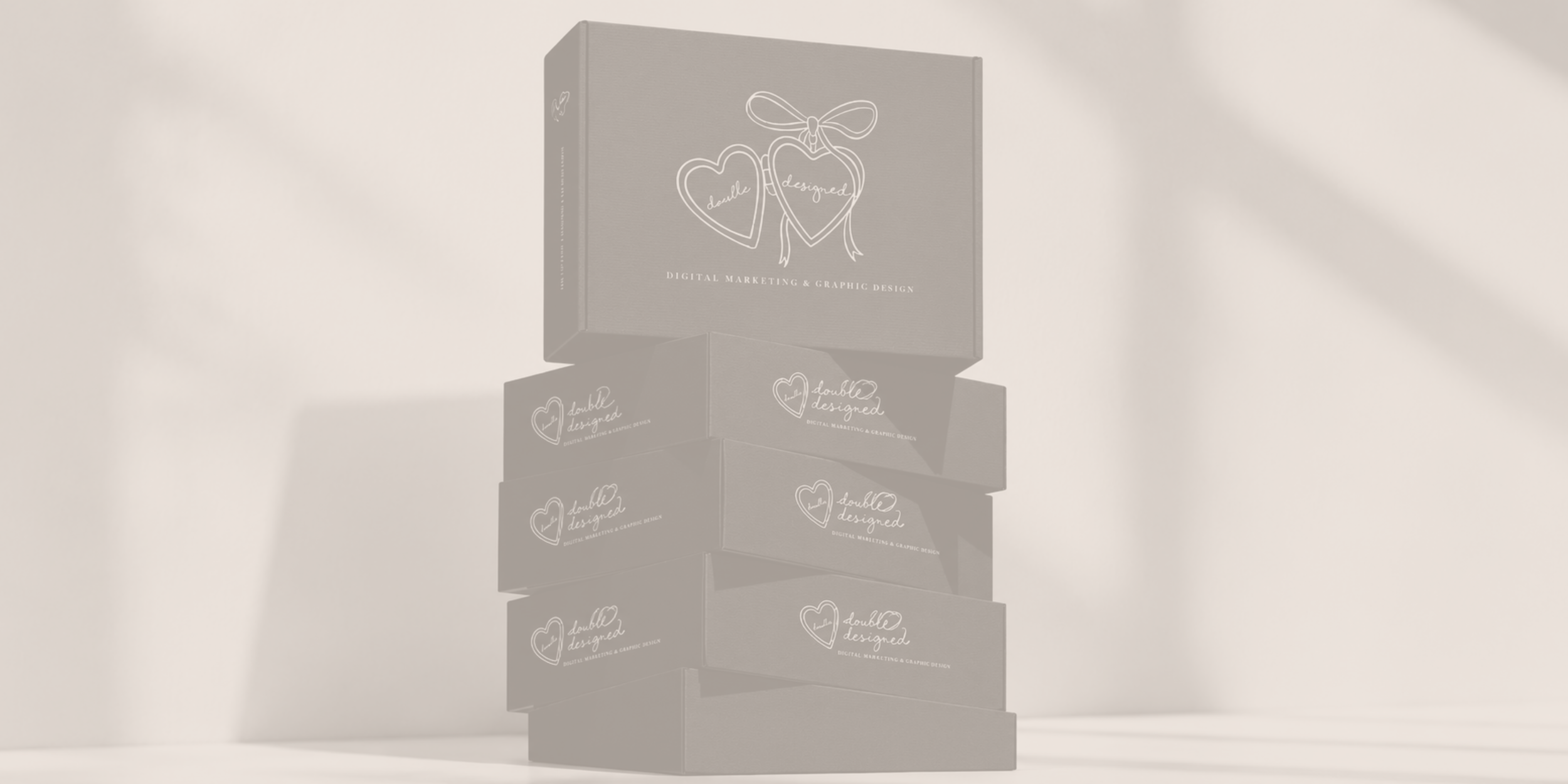 Stacked boxes with the logo 'double designed' and the tagline 'Digital Marketing & Graphic Design' printed on them.