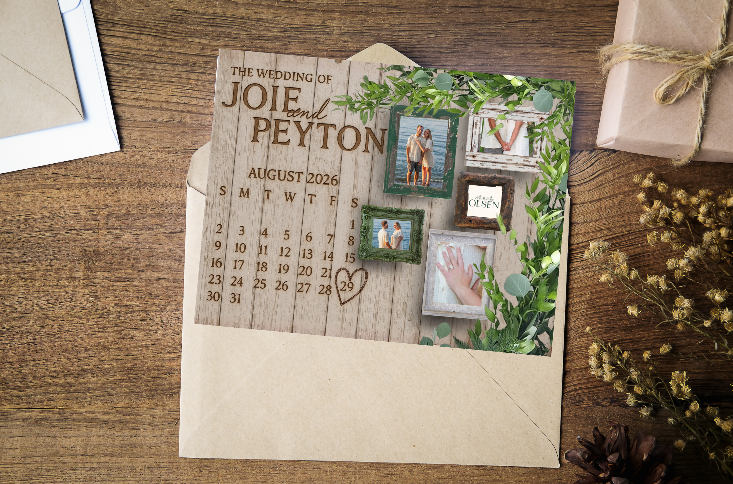 Wedding invitation with wooden background, framed photographs, greenery decor, and a small wrapped gift on a wooden table.