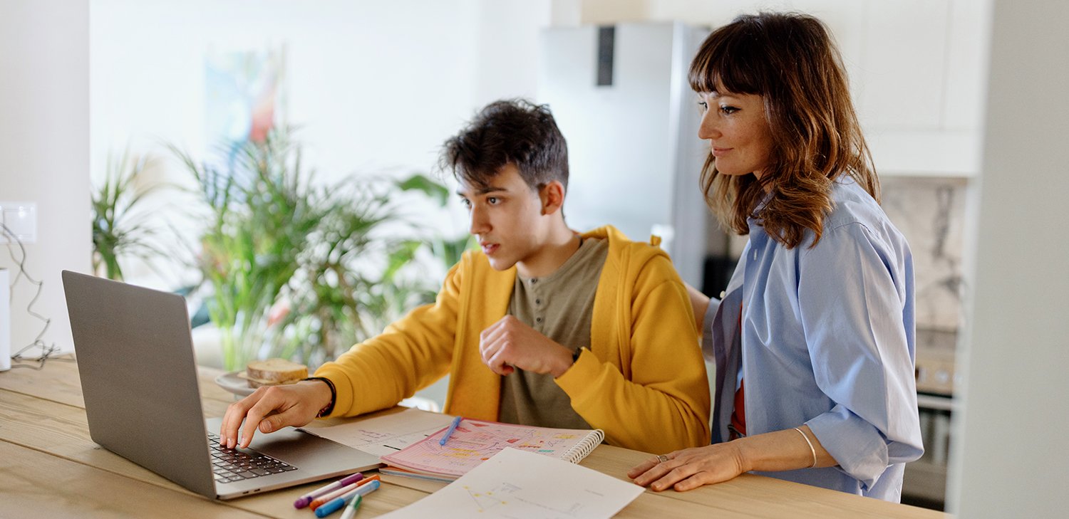 A teacher guiding a Directions to Diploma student while he studies on his computer (hero image)