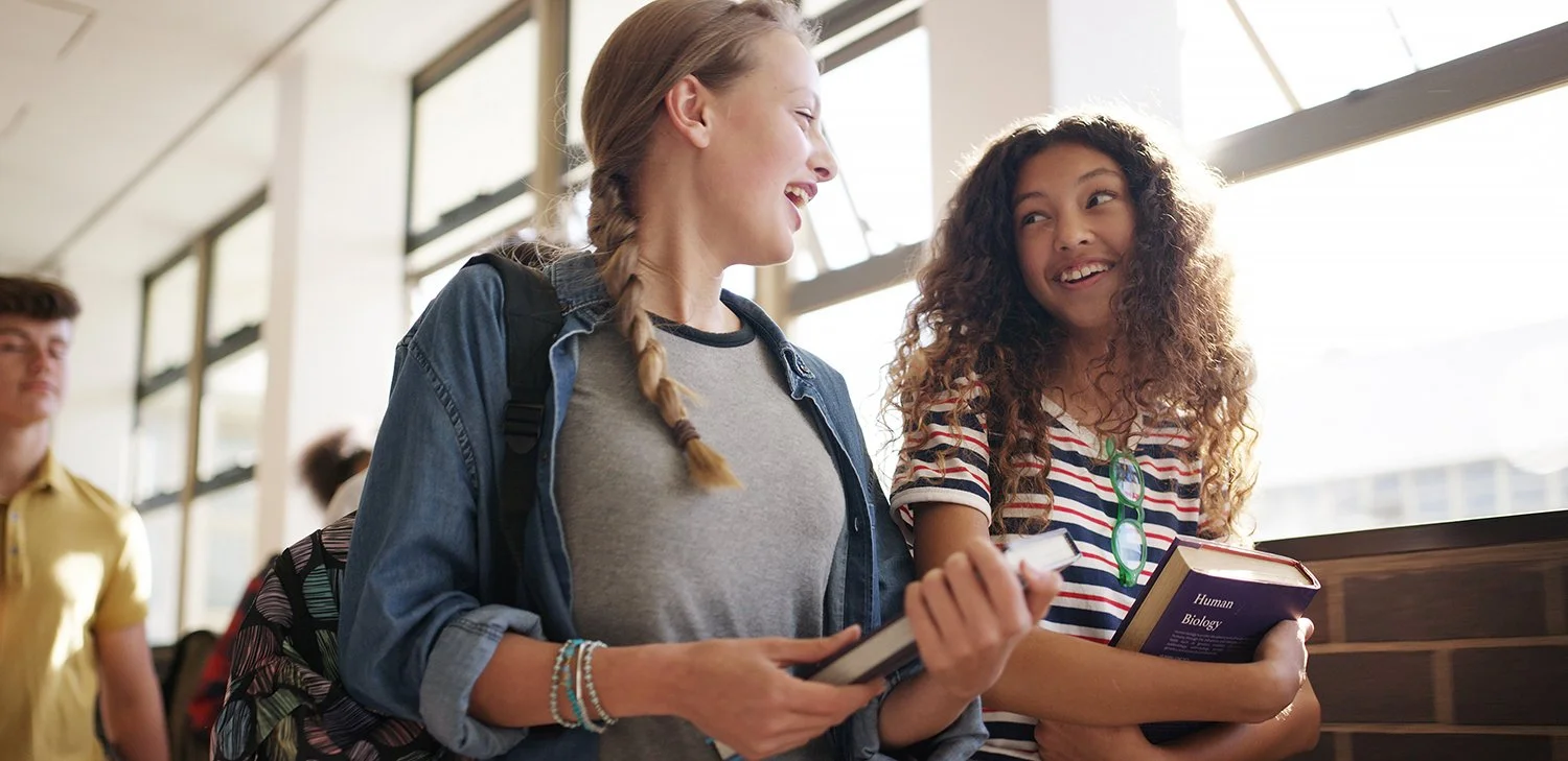 Two Students Talking In School Hallway