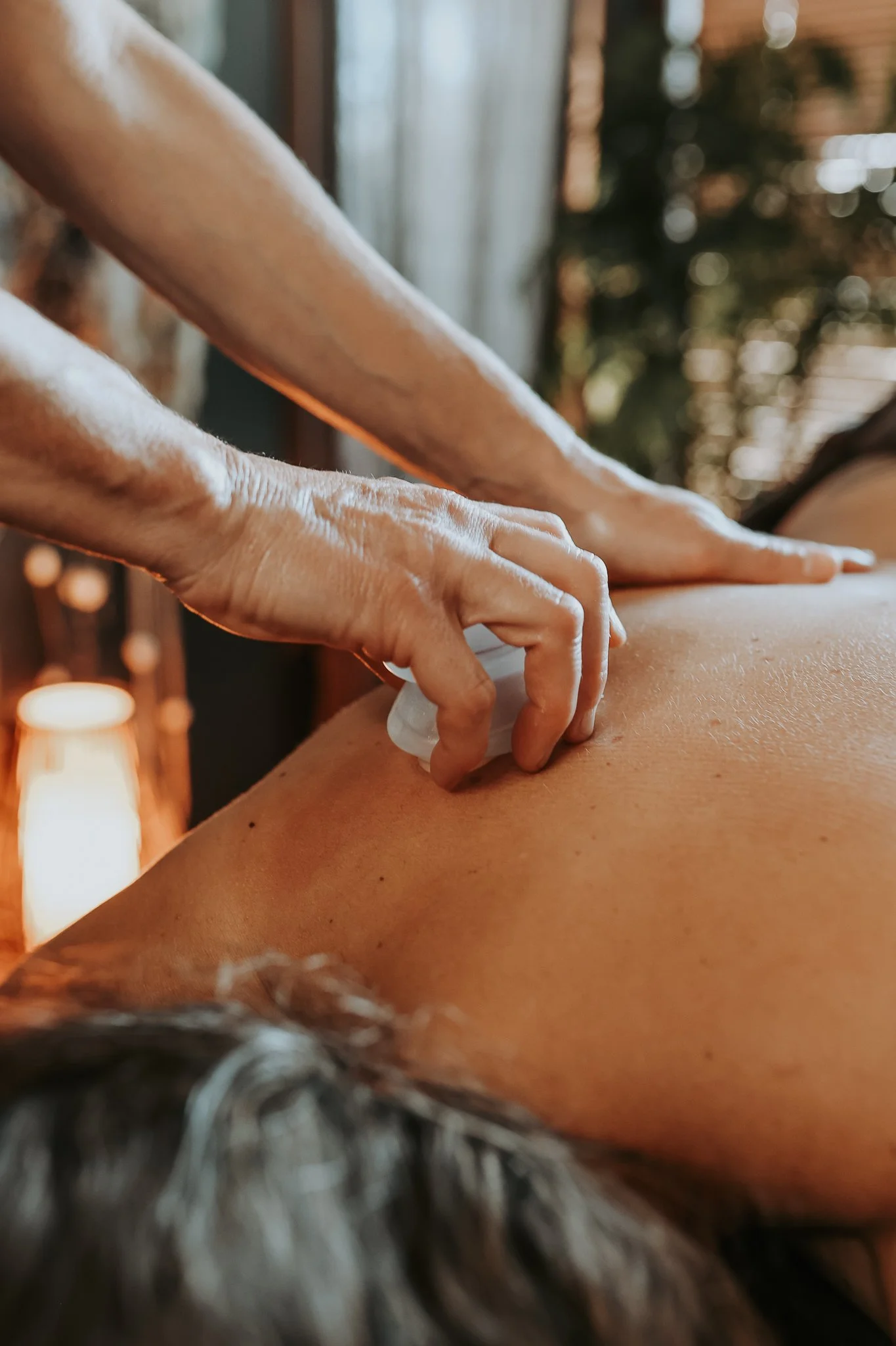 Gina is cupping a patients back while they're laying down on the massage table.