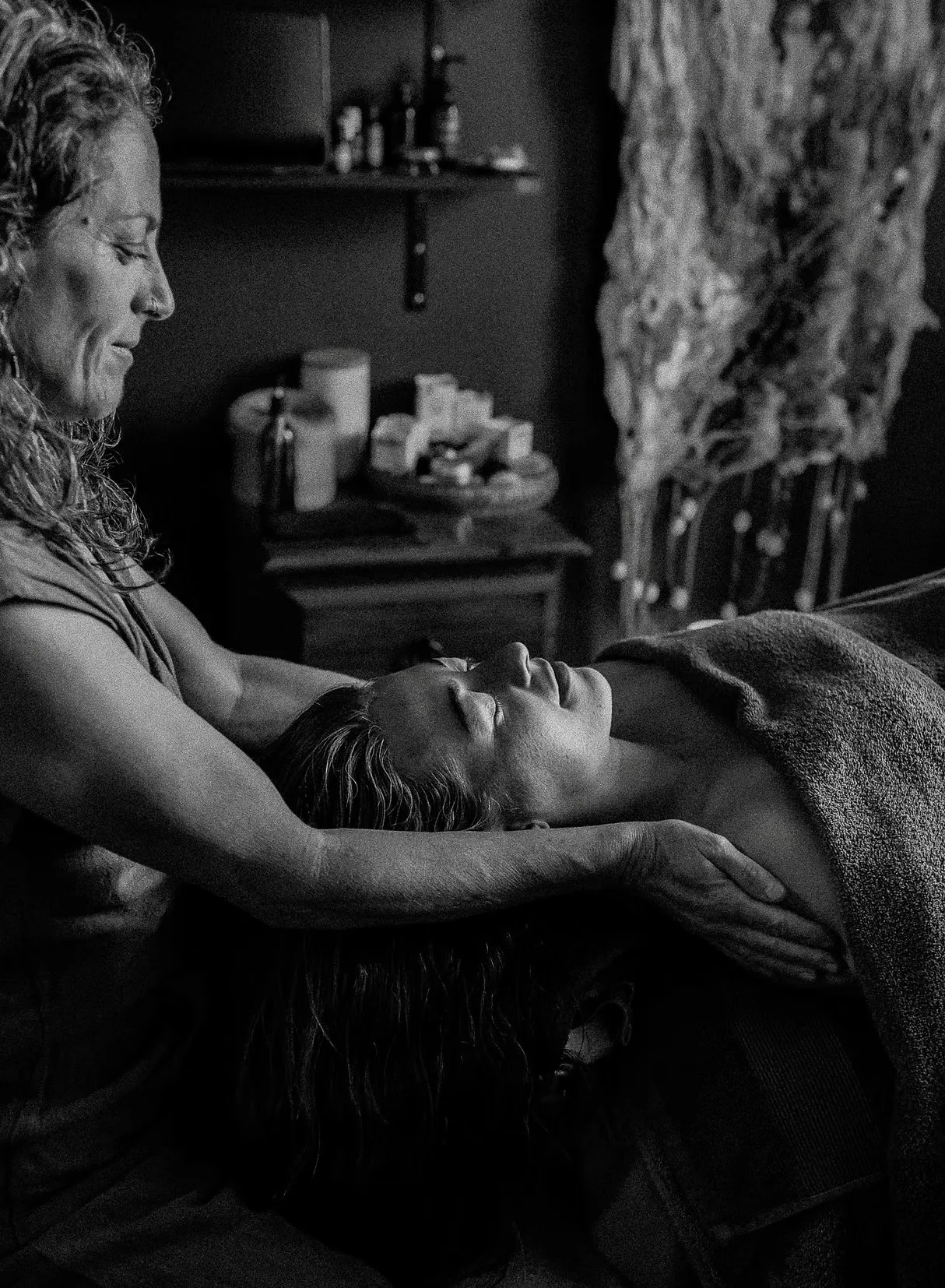 Gina is lightly stroking the client while they're relaxing on the massage table.