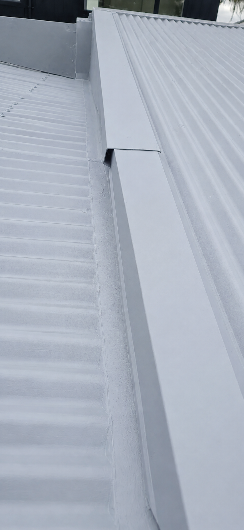 Metal roof primer applied to prepared and rust-treated roofing