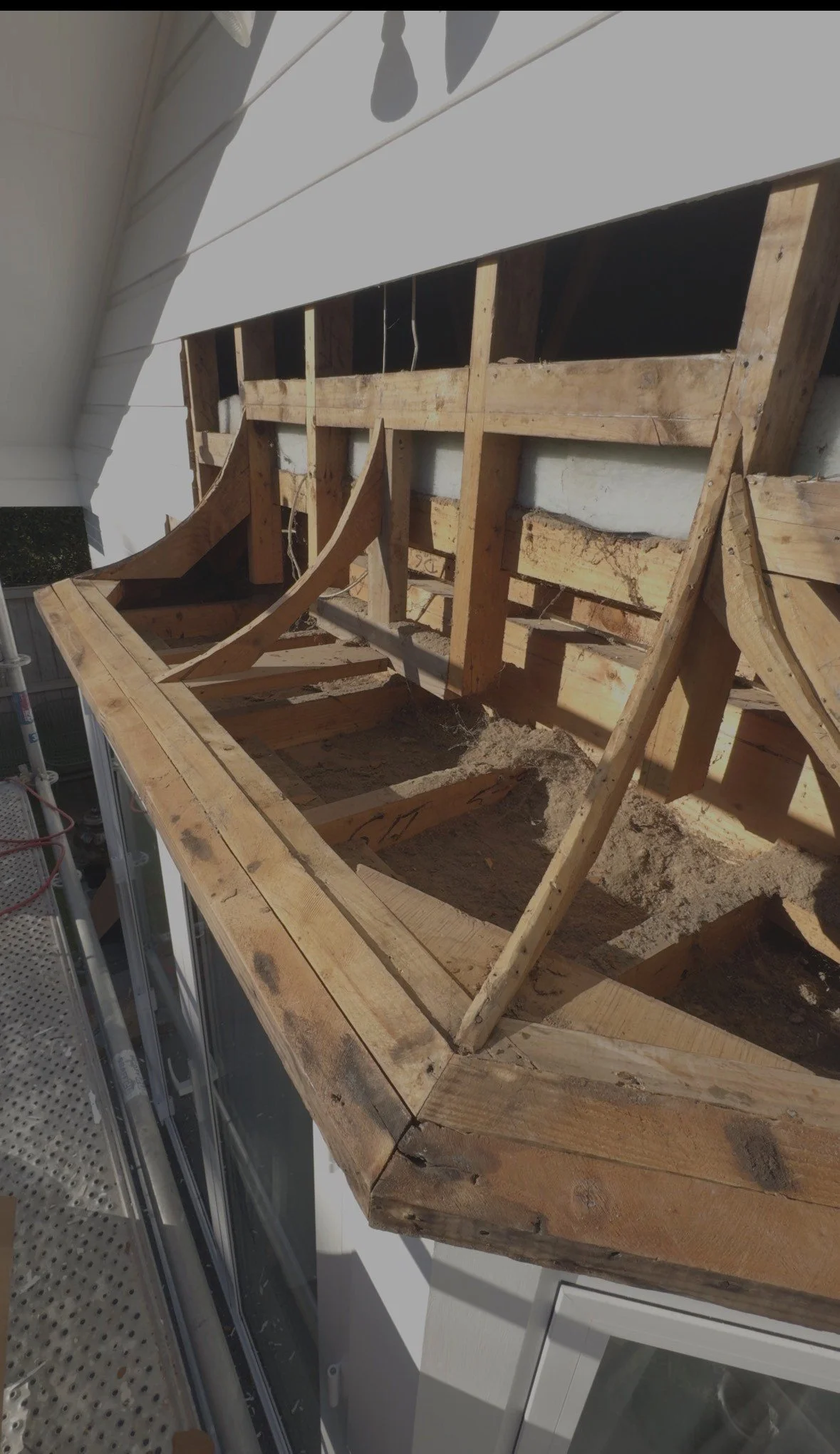 Exterior cladding removed to expose damaged timber framing around a window