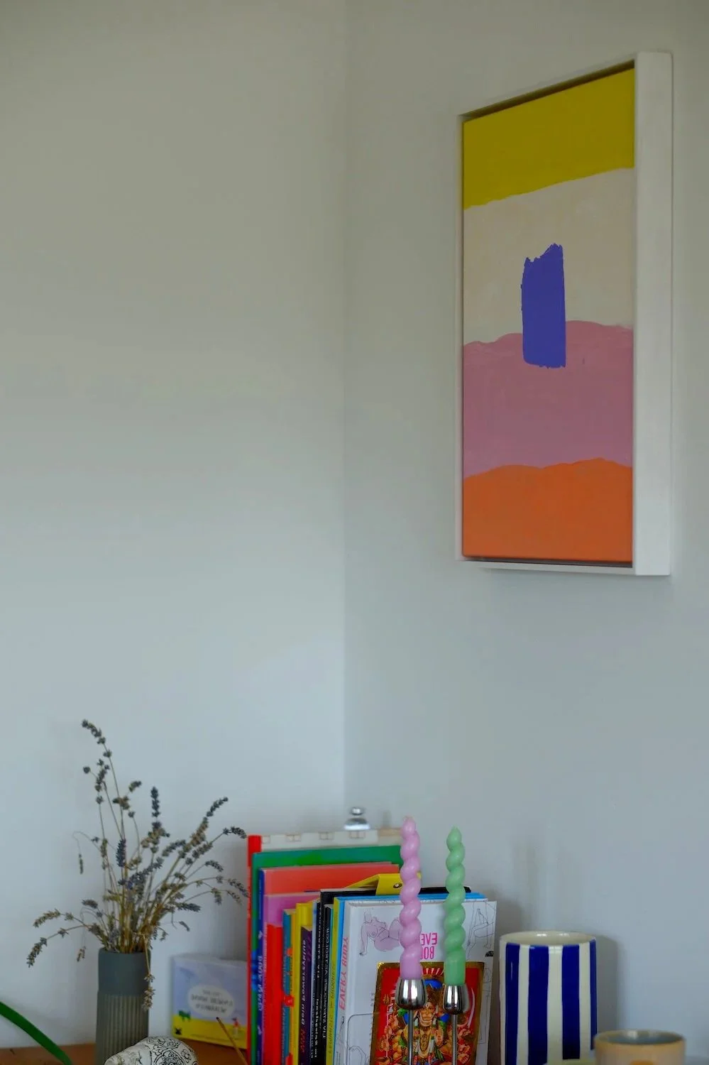 Bücherregal mit Dekoration und abstrakter Wandkunst im Wartebereich