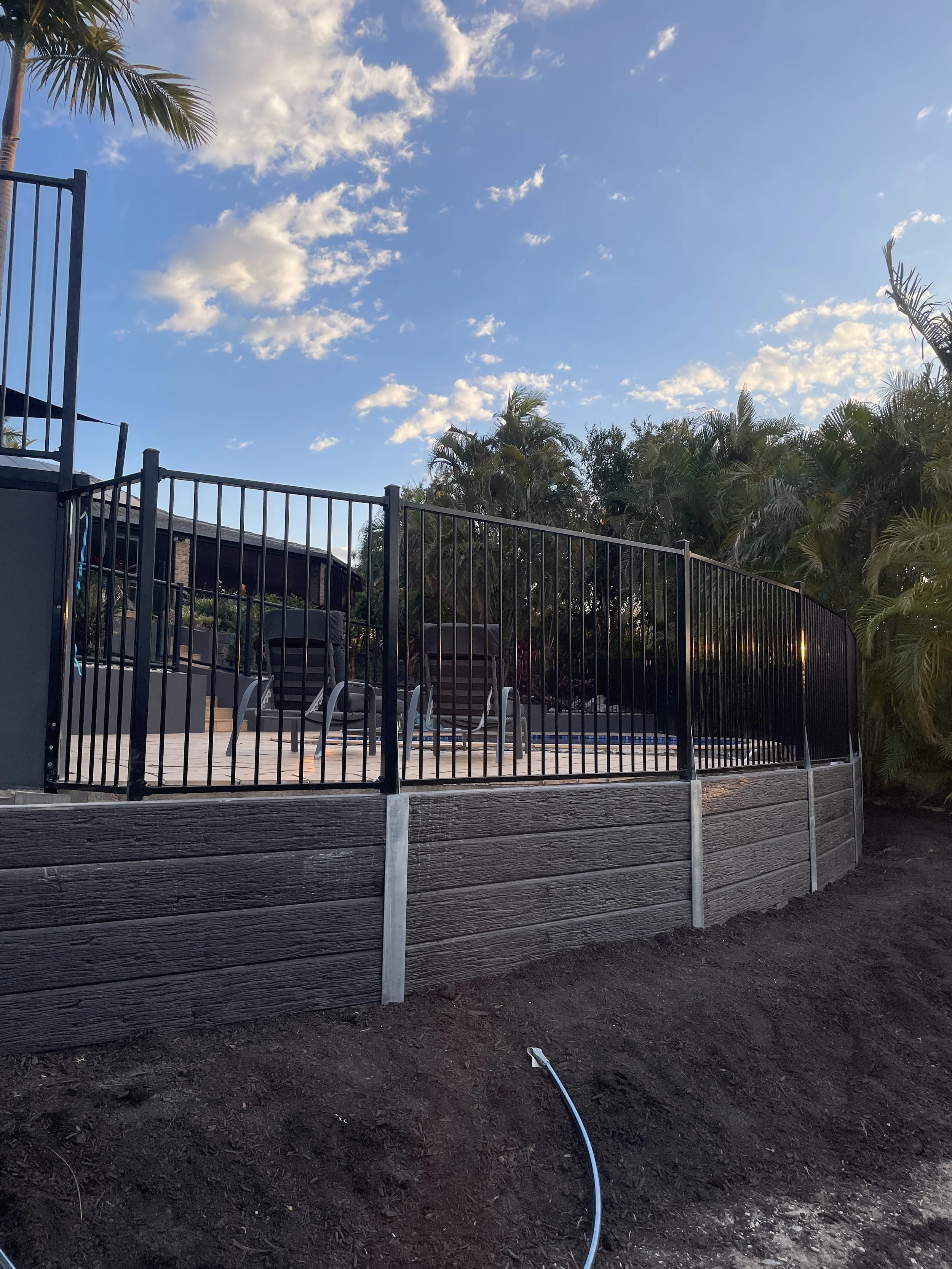 Charocal concrete retaining wall with pool fencing completed in Helensvale