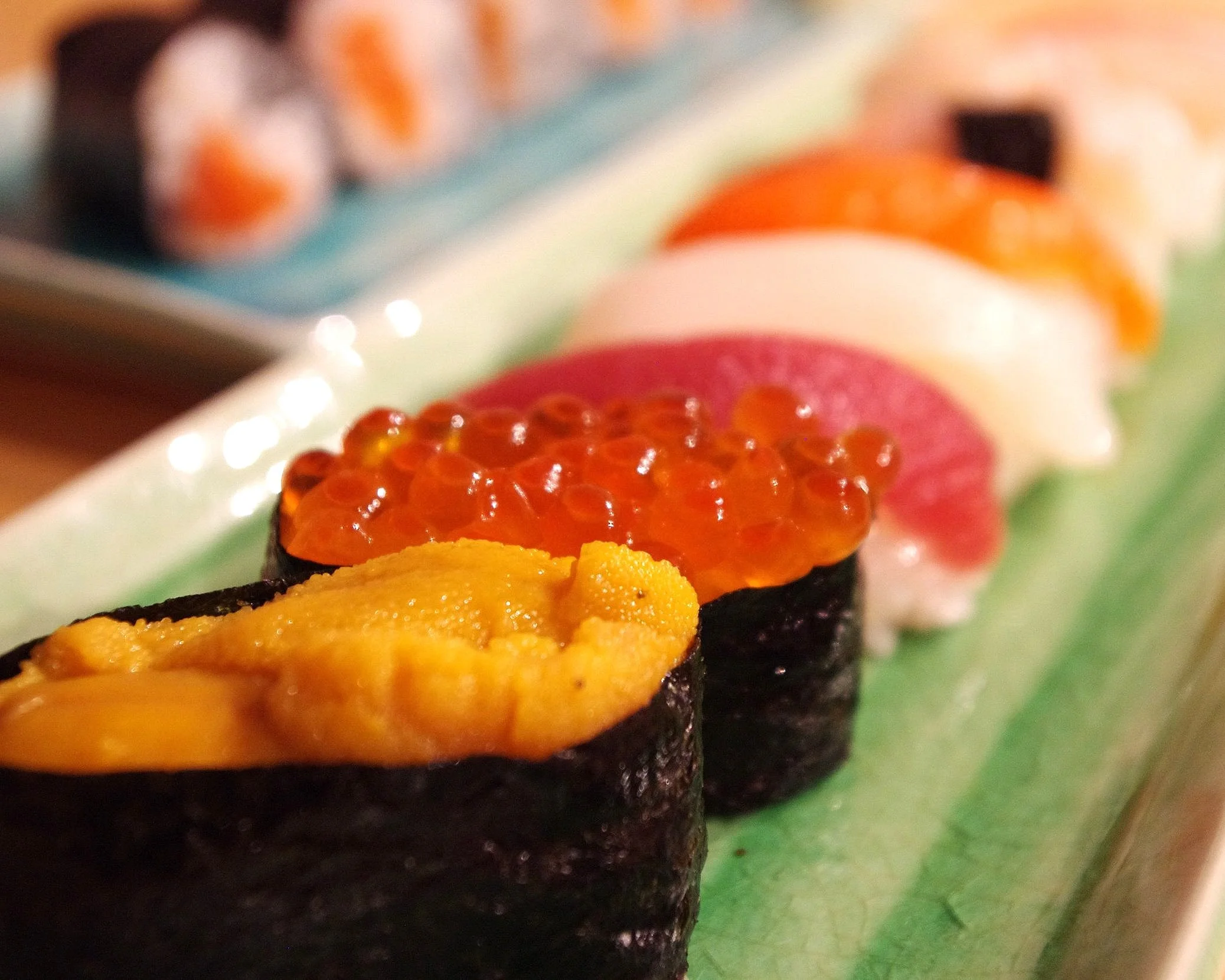 Sushi plate with uni in the foreground