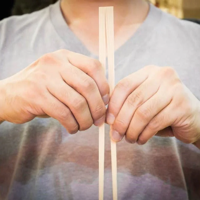 man breaking chopsticks apart