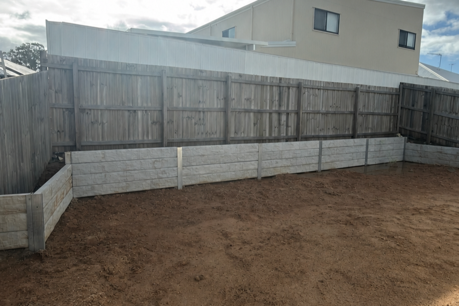 Concrete sleeper retaining wall completed with excavation, drainage and site preparation to create a stable and functional outdoor area.