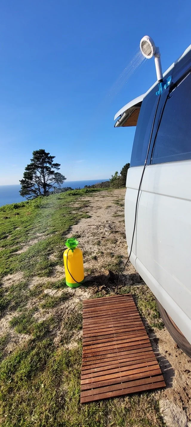 Douche de camping fixée sur le toit d'un véhicule blanc, MalavanBox - amenagement sur mesure vanlife